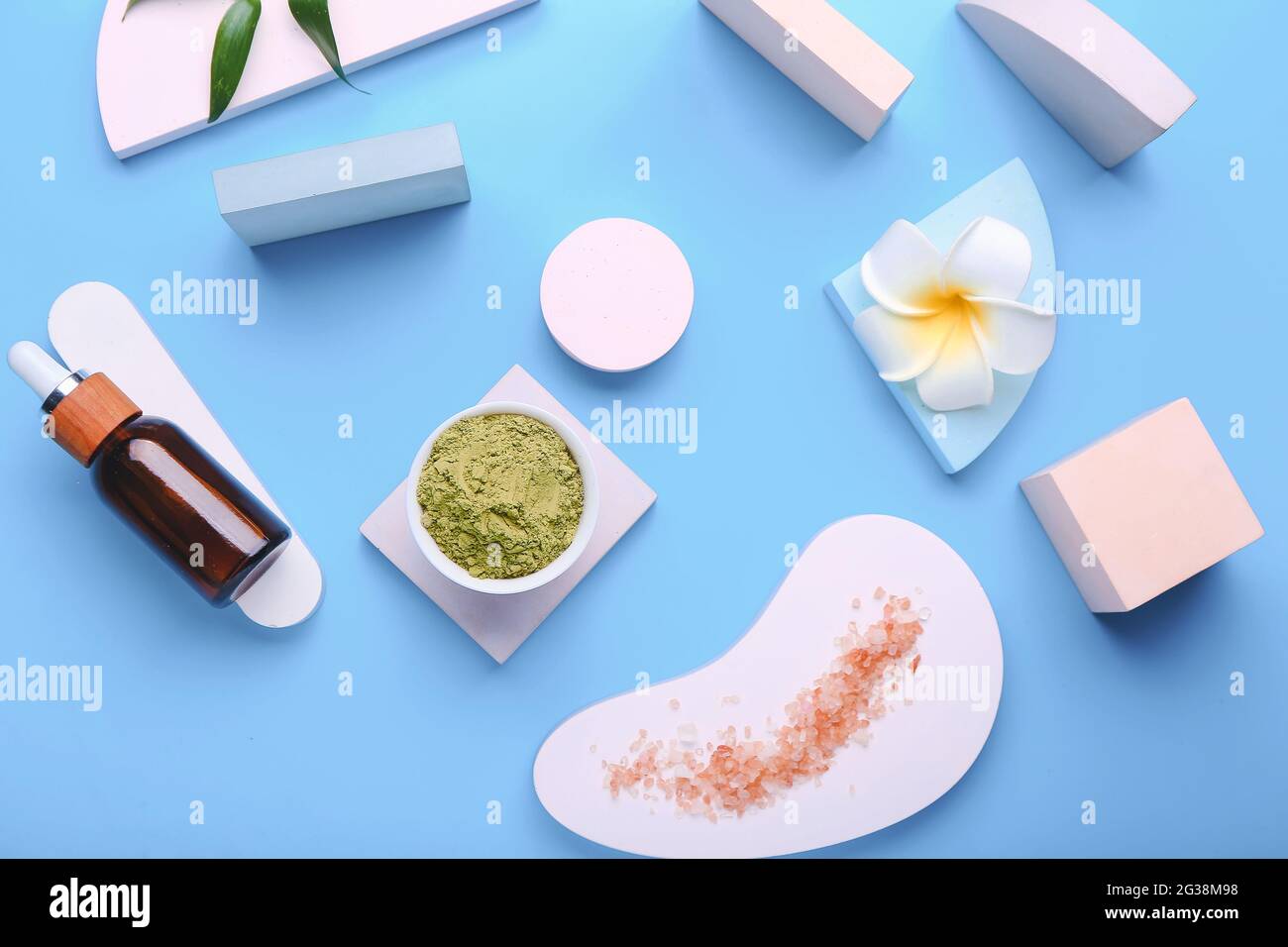 Composition with dry henna powder in bowl, bottle of essential oil and