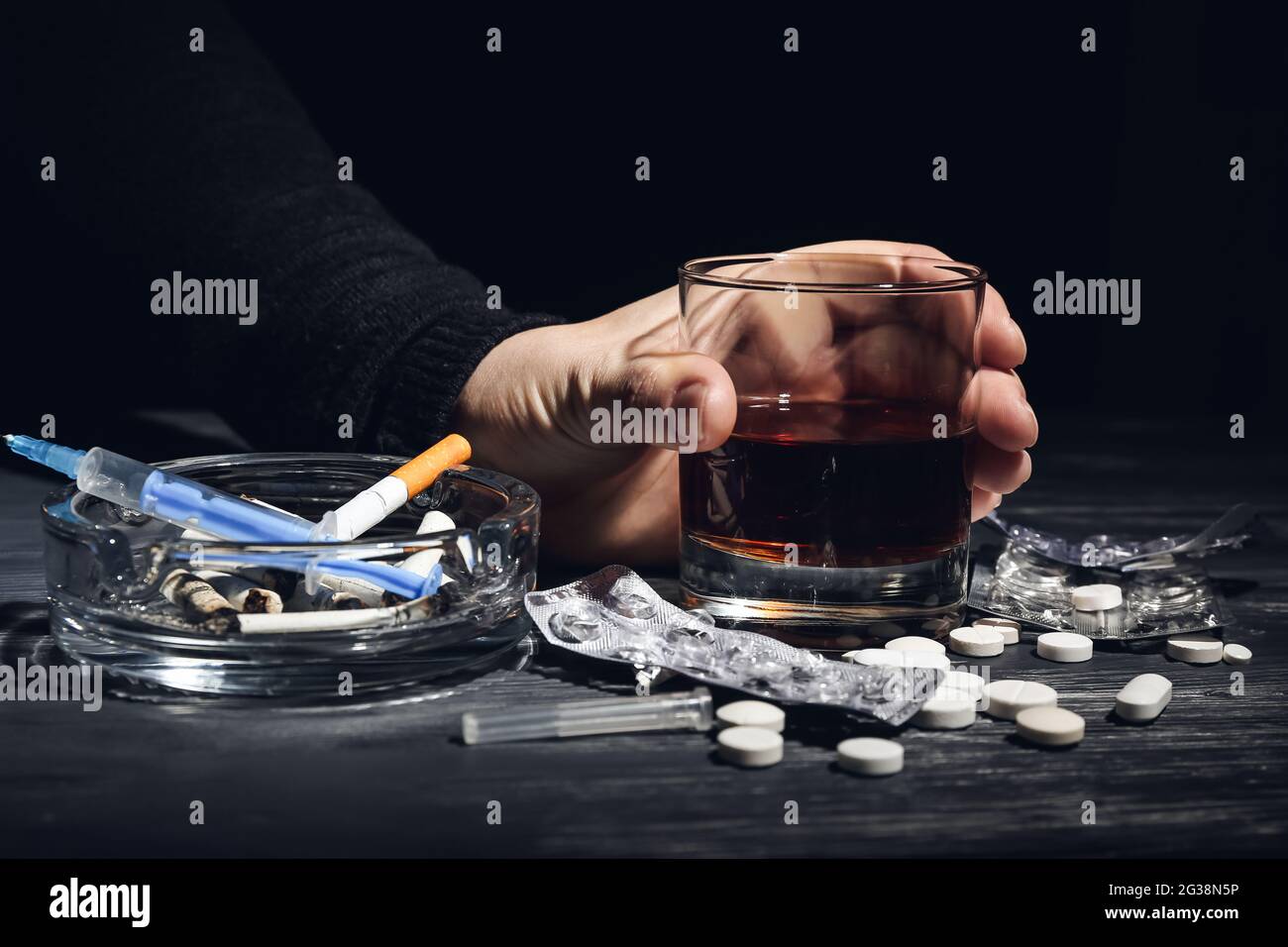 Junkie with drugs, cigarettes and alcohol at table, closeup Stock Photo