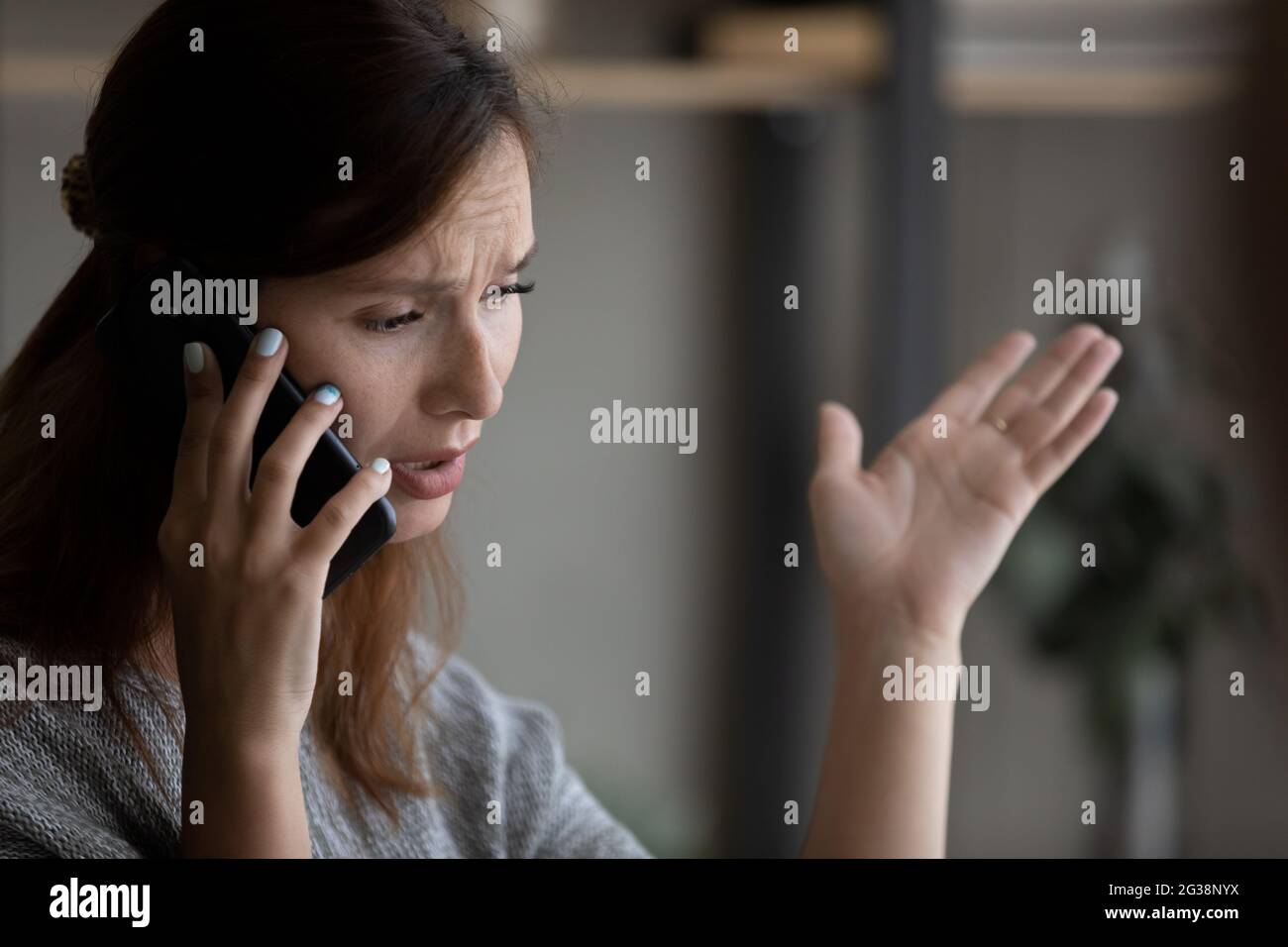 Close up unhappy woman talking on phone, having unpleasant conversation Stock Photo