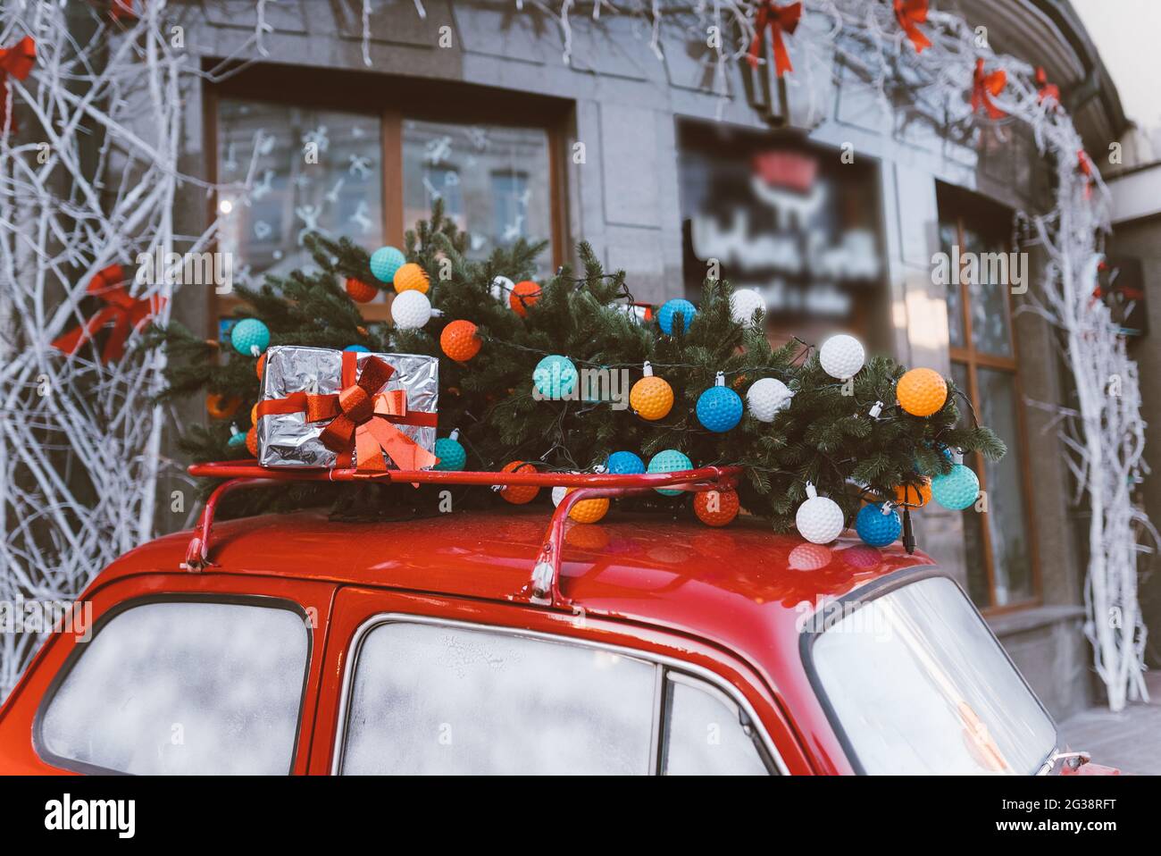 Red retro car with a Christmas tree fir tied to the roof Stock Photo ...