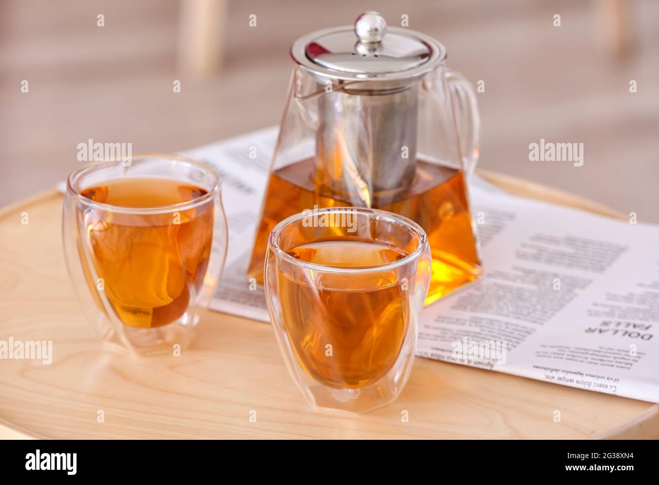 Teapot and cups of hot beverage on table in room Stock Photo Alamy
