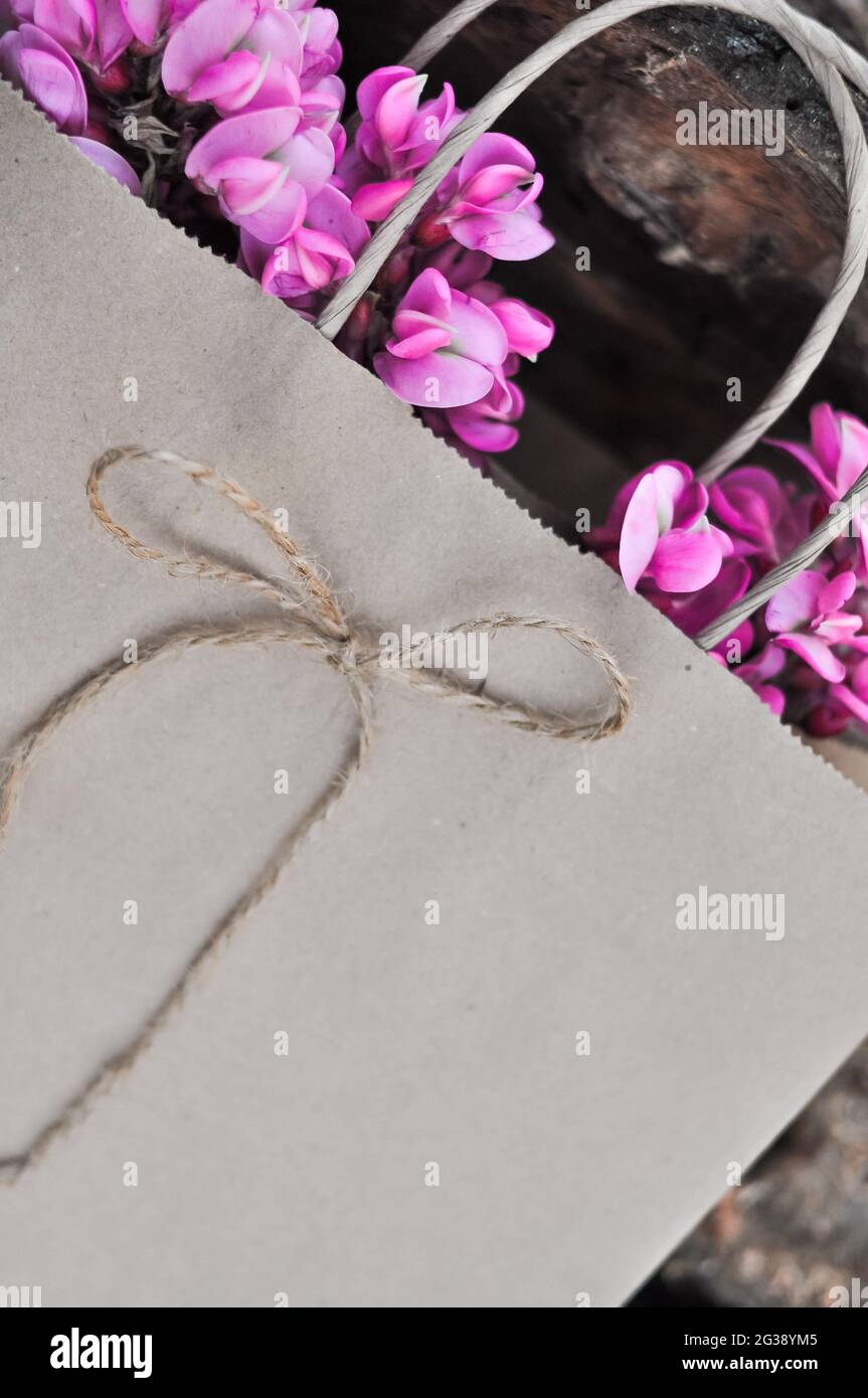 disposable paper craft eco bag with pink acacia flowers, zero waste concept Stock Photo