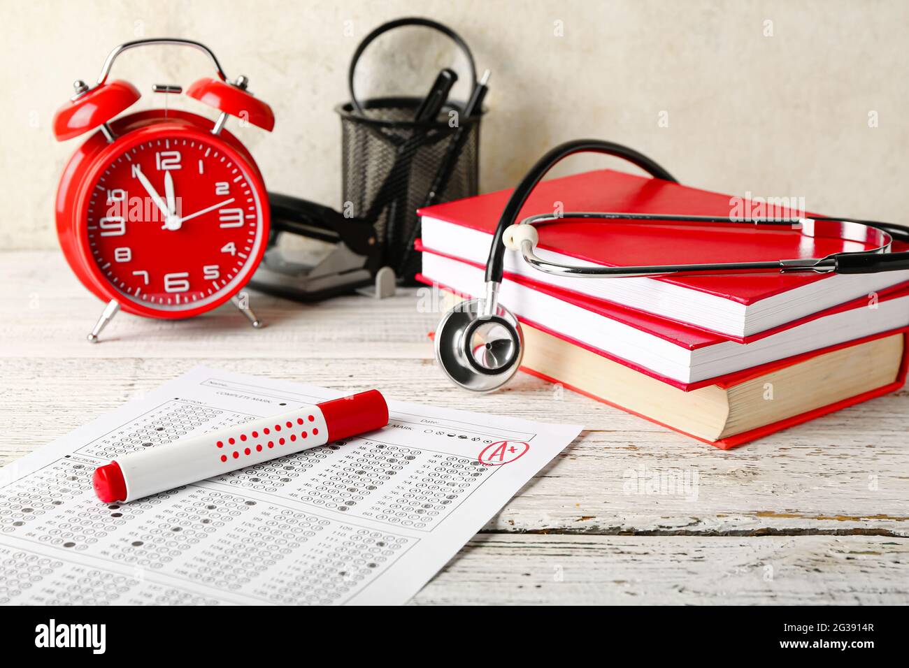 Composition with answer sheet, stethoscope and alarm clock on wooden table Stock Photo