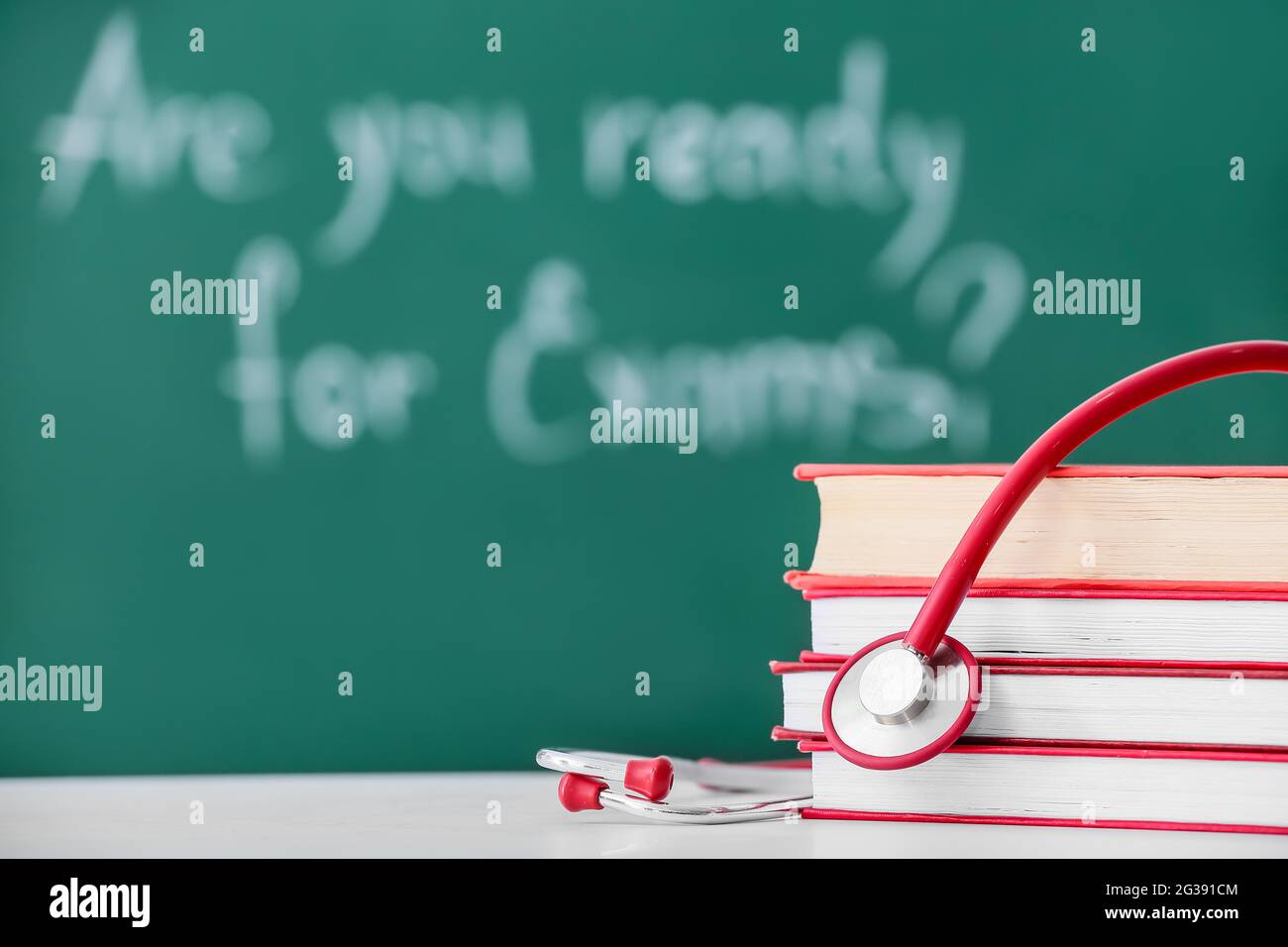Stack of books and stethoscope on table in classroom Stock Photo - Alamy