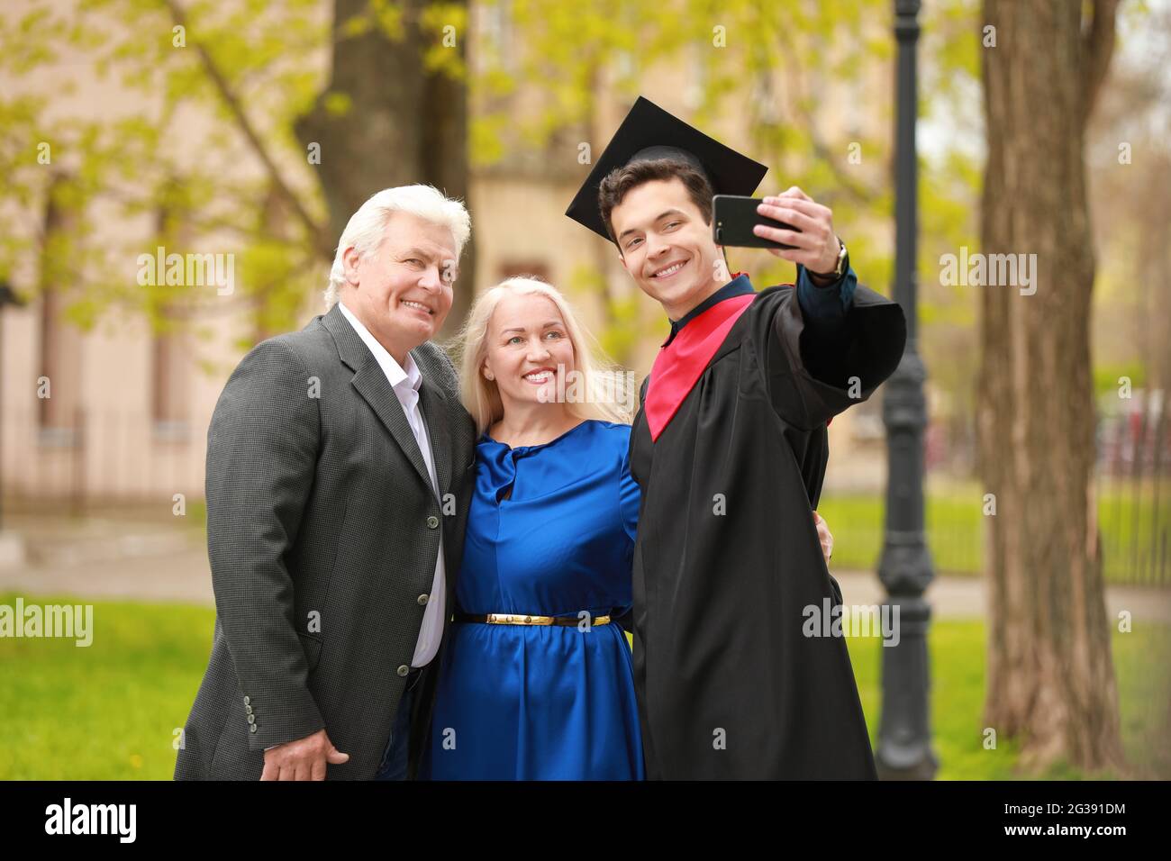 Happy young man with his parents on graduation day Stock Photo - Alamy