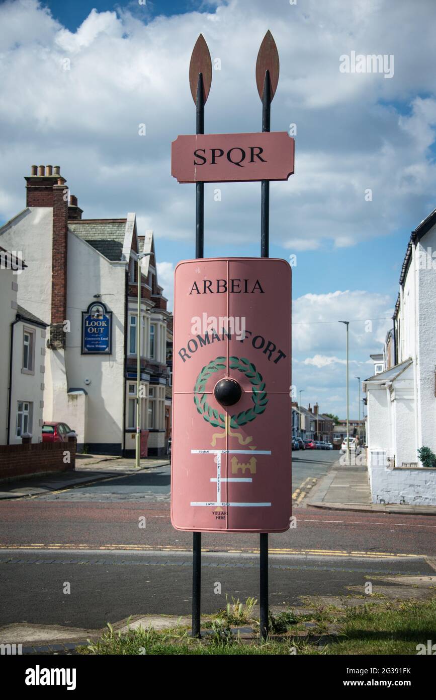 Sign post styled with a Legionary shield and javelins leading to the archeological site of the Roman fort Arbeia in South Shields at the mouth of the river Tyne. Stock Photo