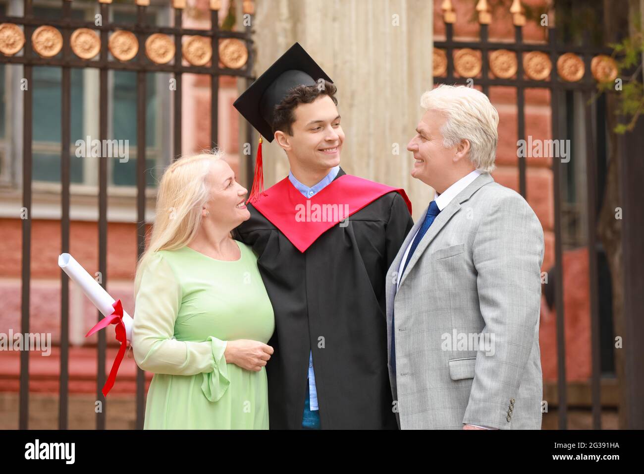 Happy young man with his parents on graduation day Stock Photo - Alamy