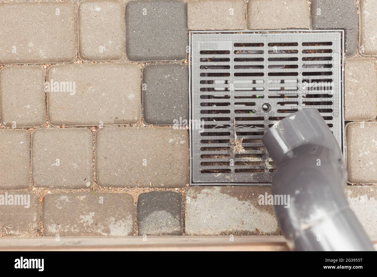 stormwater pipe on facade with rainwater drainage into the drainage system  with a sewer manhole grill Stock Photo - Alamy