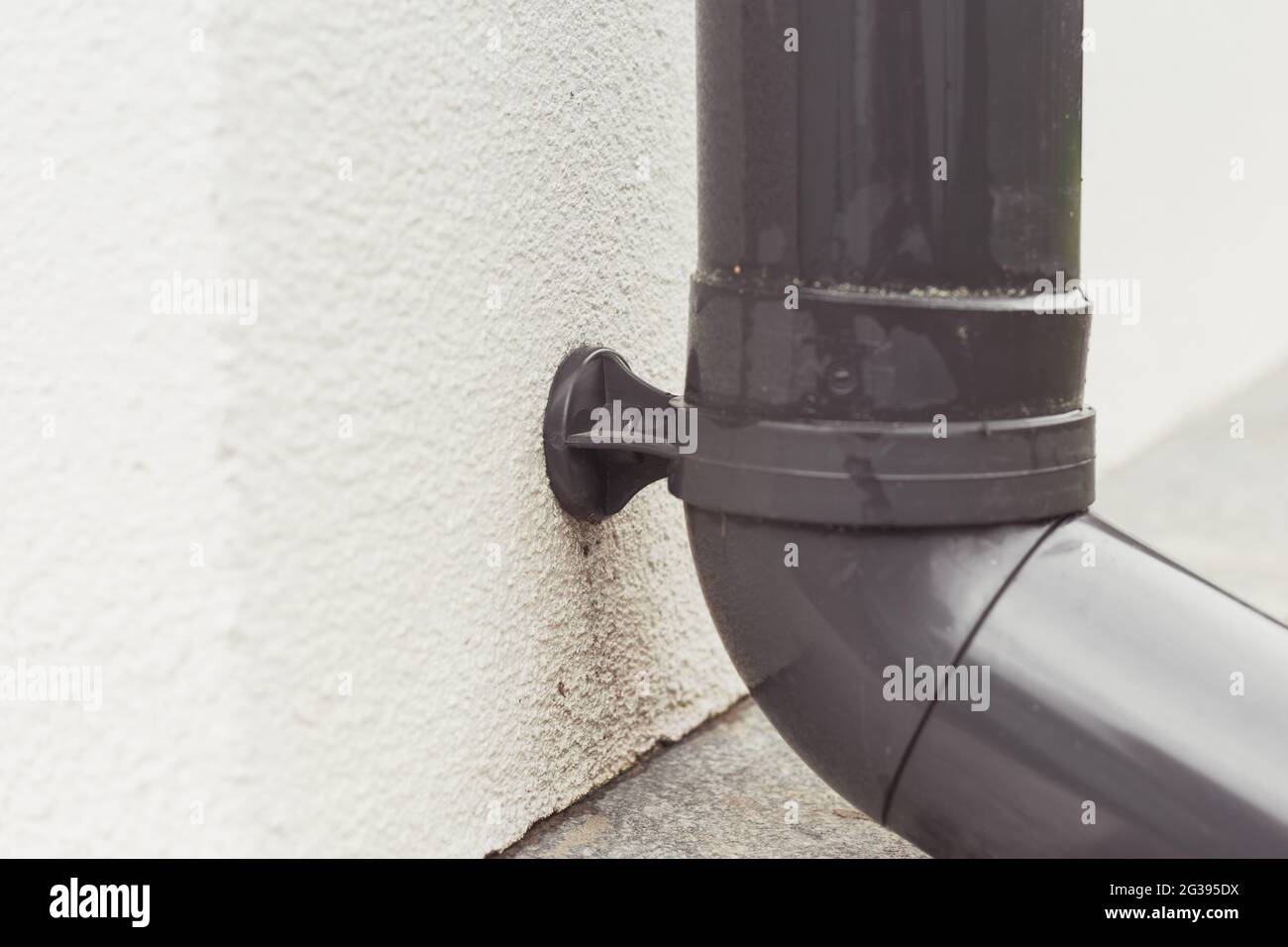 Pipe clamp with gutter system polymer pipe fastened on wall