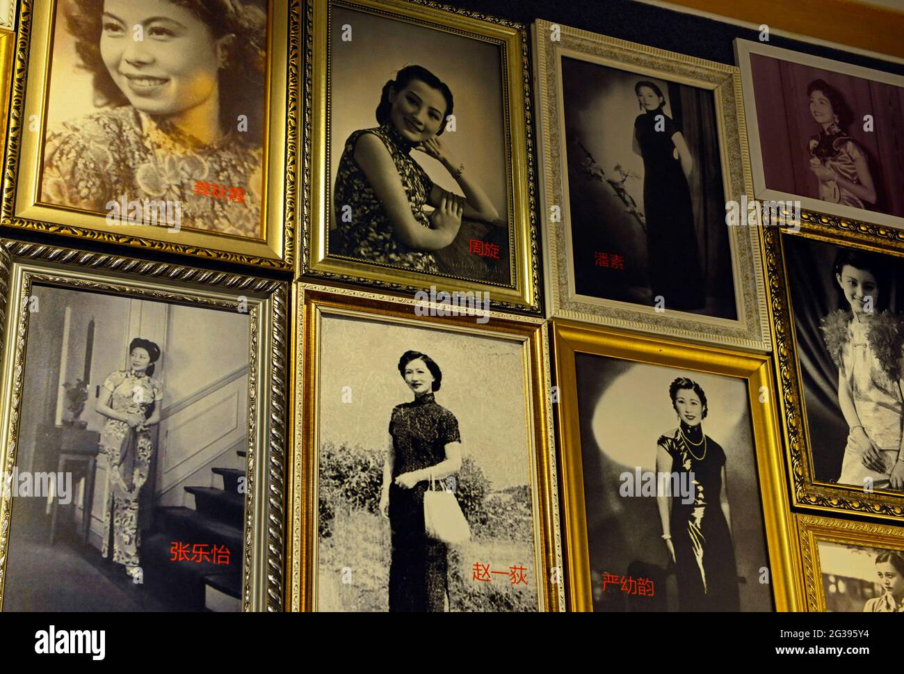 Photos of famous Chinese women in years past all wearing the Qipao dress line the walls at the Qipao museum in an old house in Yantai, China Stock Photo