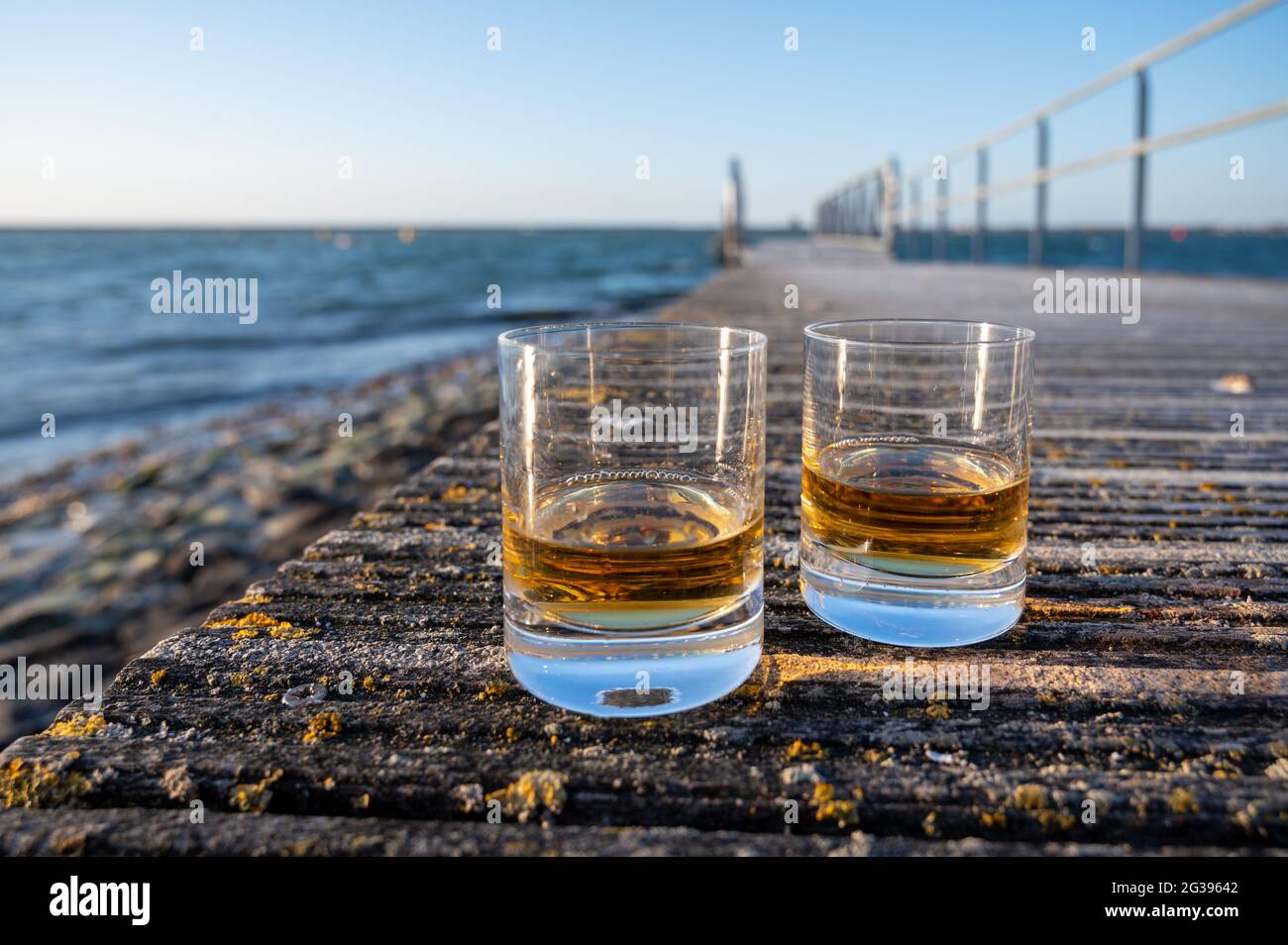 Drinking single malt Scotch whisky at sunset with sea, ocean or river