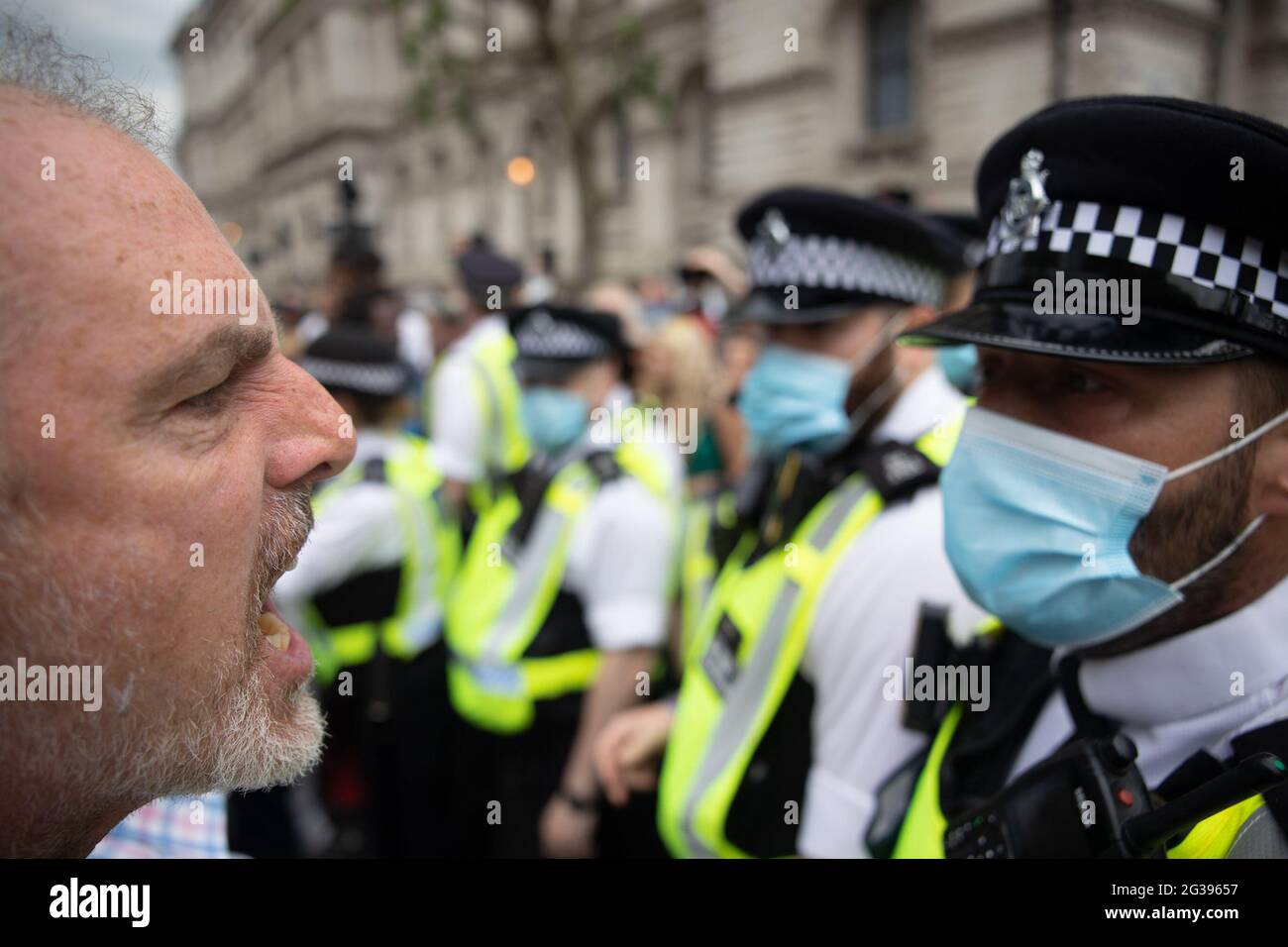 London, UK. 14th June 2021. Anti-vaxx protester confronts police officer outside Parliament. Yuen Ching Ng/Alamy Live News Yuen Ching Ng/Alamy Live News Stock Photo