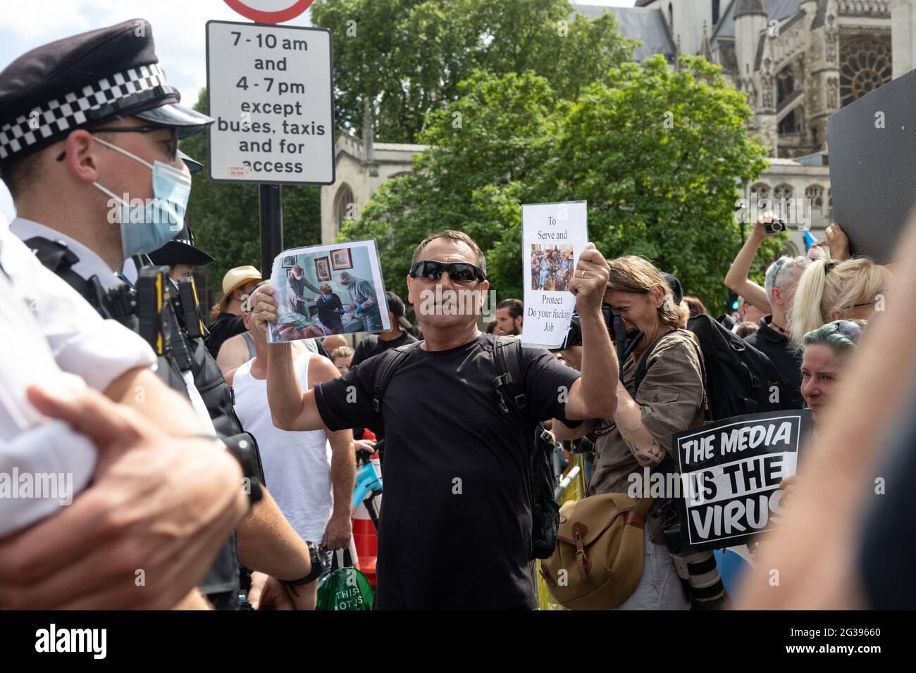 London, UK. 14th June 2021. Anti-vaxx protester confronts police officer outside Parliament. Yuen Ching Ng/Alamy Live News Stock Photo