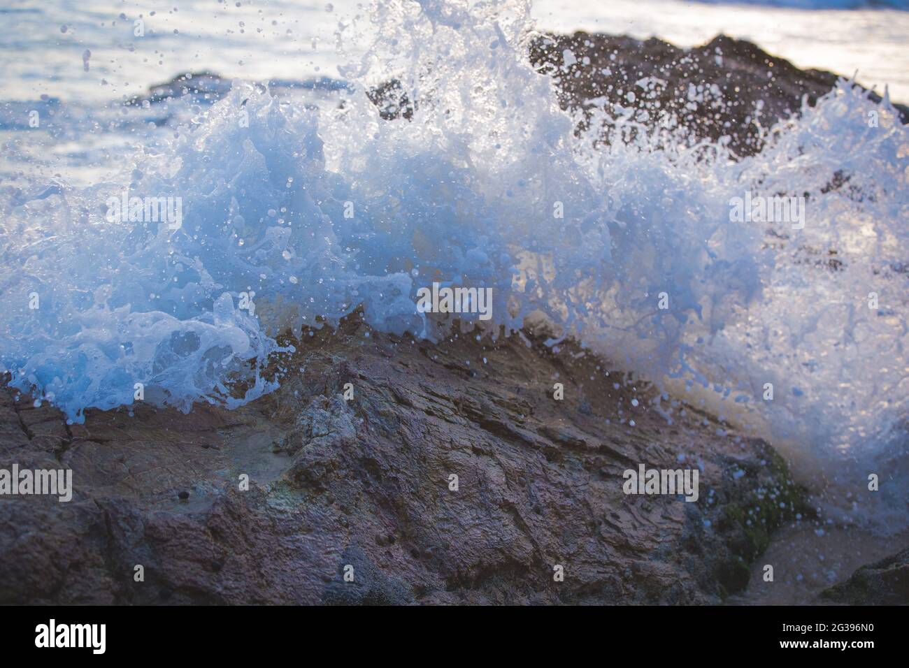 Closeup of sea water splashing on the rough rocks Stock Photo - Alamy