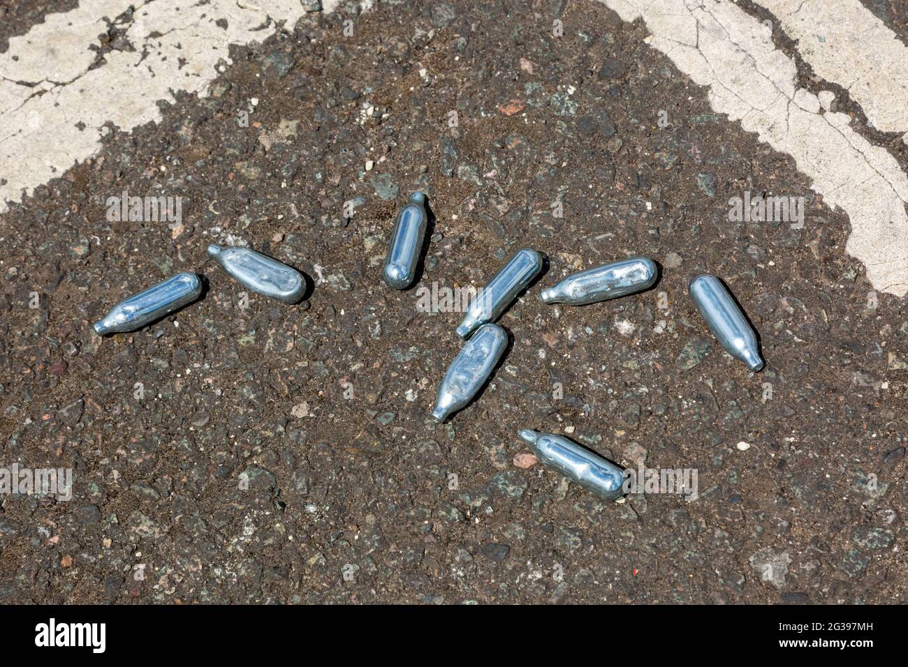 Nitrous oxide canisters on a road, UK Stock Photo Alamy