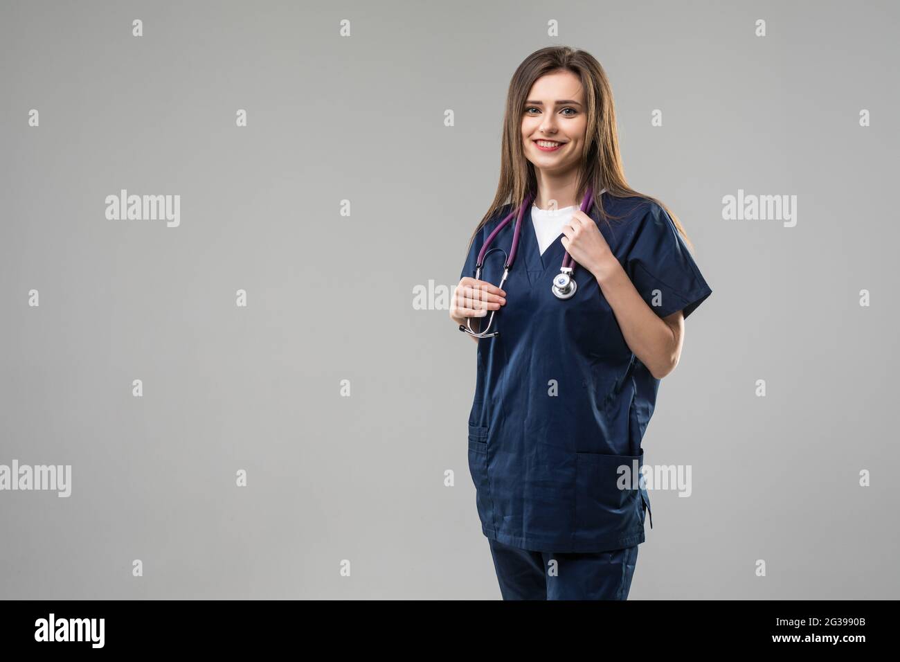 Doctor woman with stethoscope standing near grey wall Stock Photo - Alamy