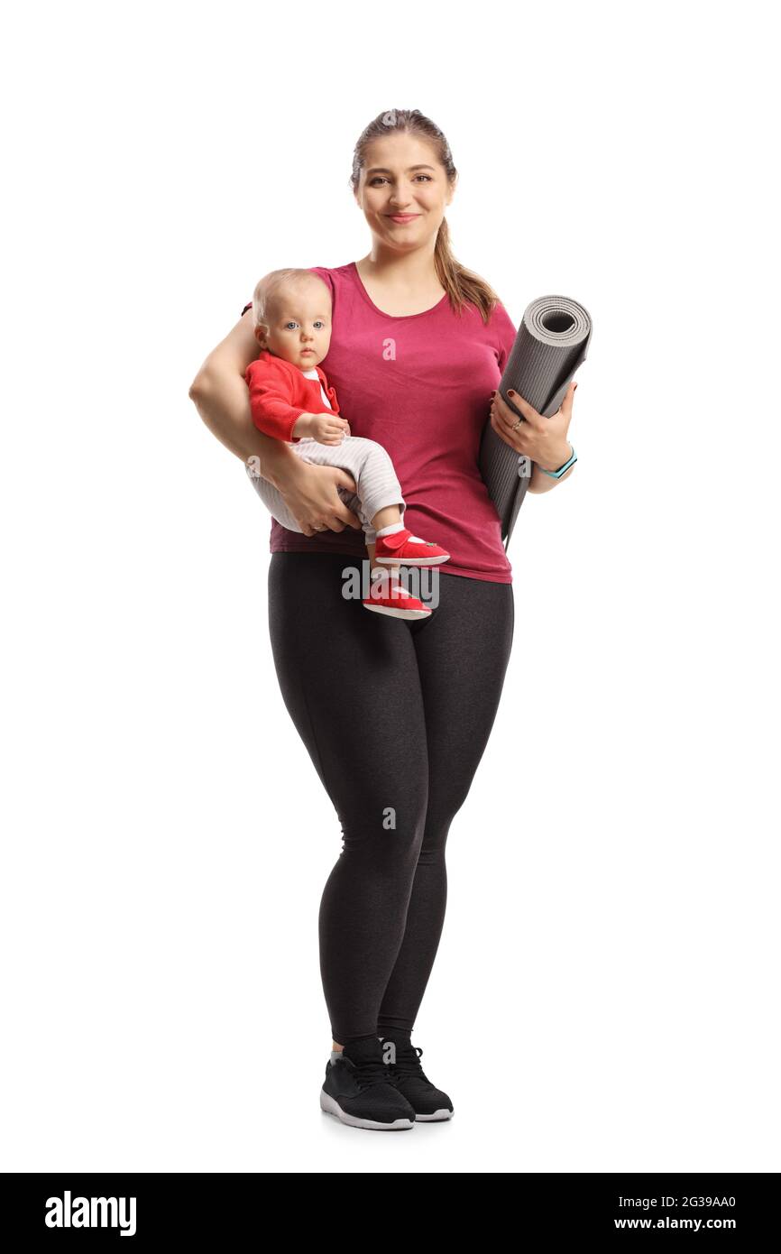 Full length portrait of a mother holding a baby and an exercise mat isolated on white background Stock Photo