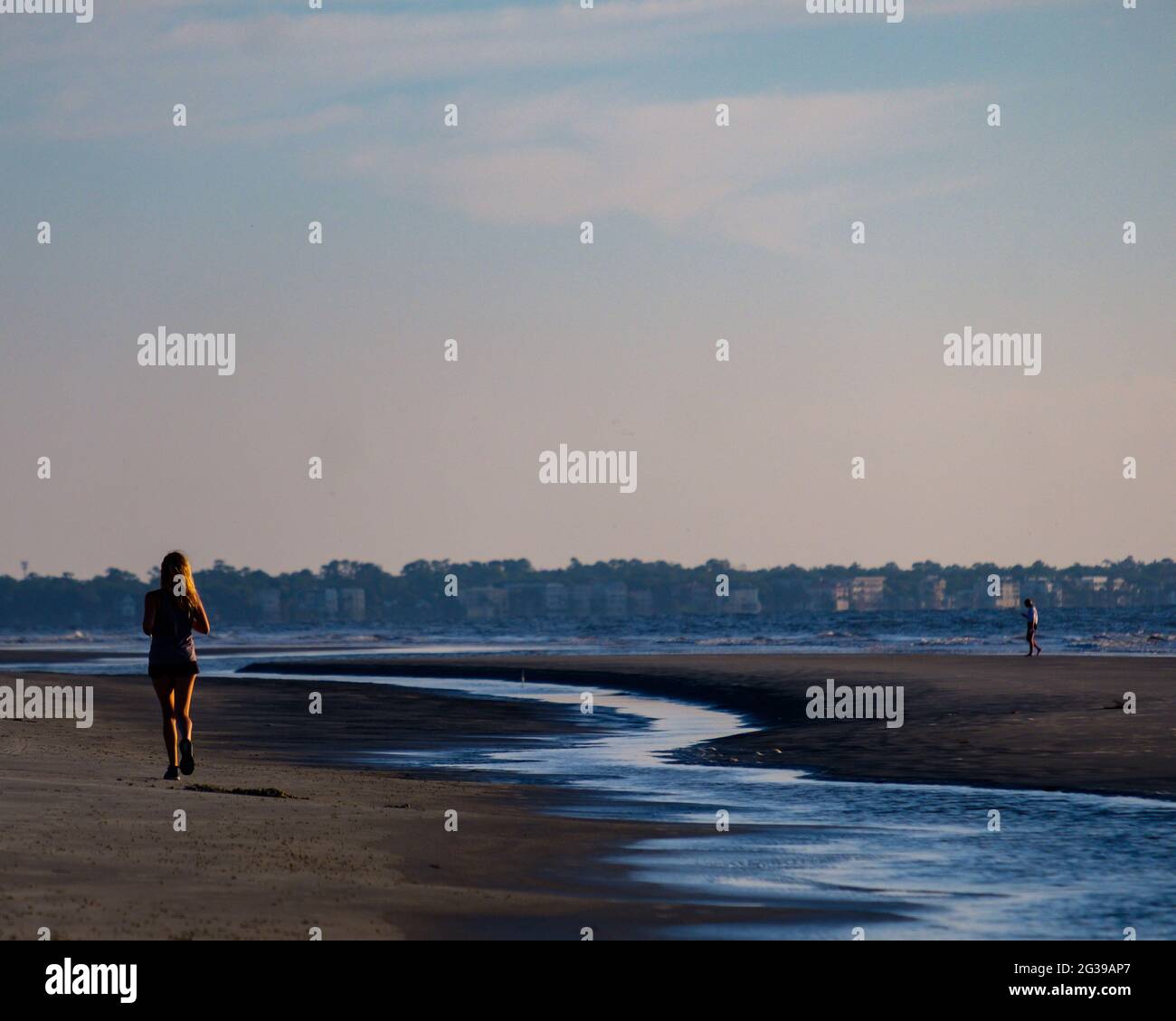 Lone female jogger on beach at Fort Walton Beach FL at sunrise. Stock Photo