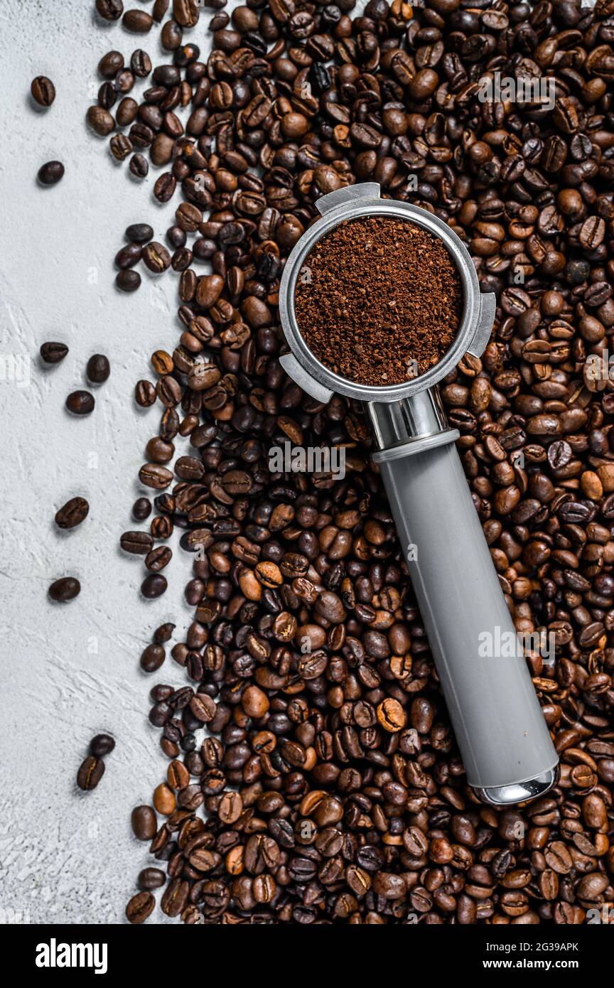 Ground Coffee in Portafilter for Espresso with coffee beans. White