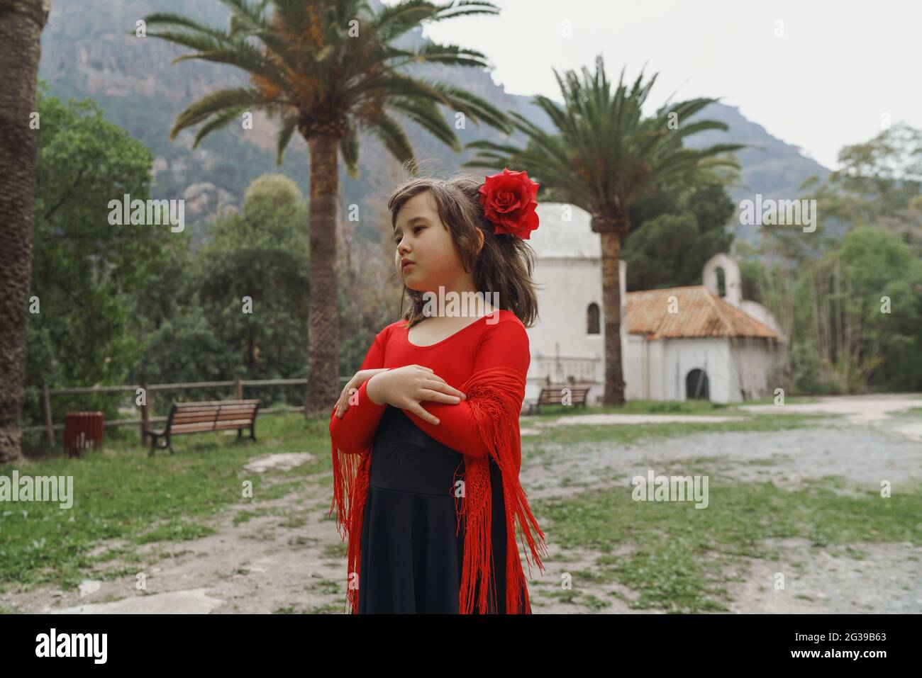 Little girl standing in the garden in Spanish dress Stock Photo