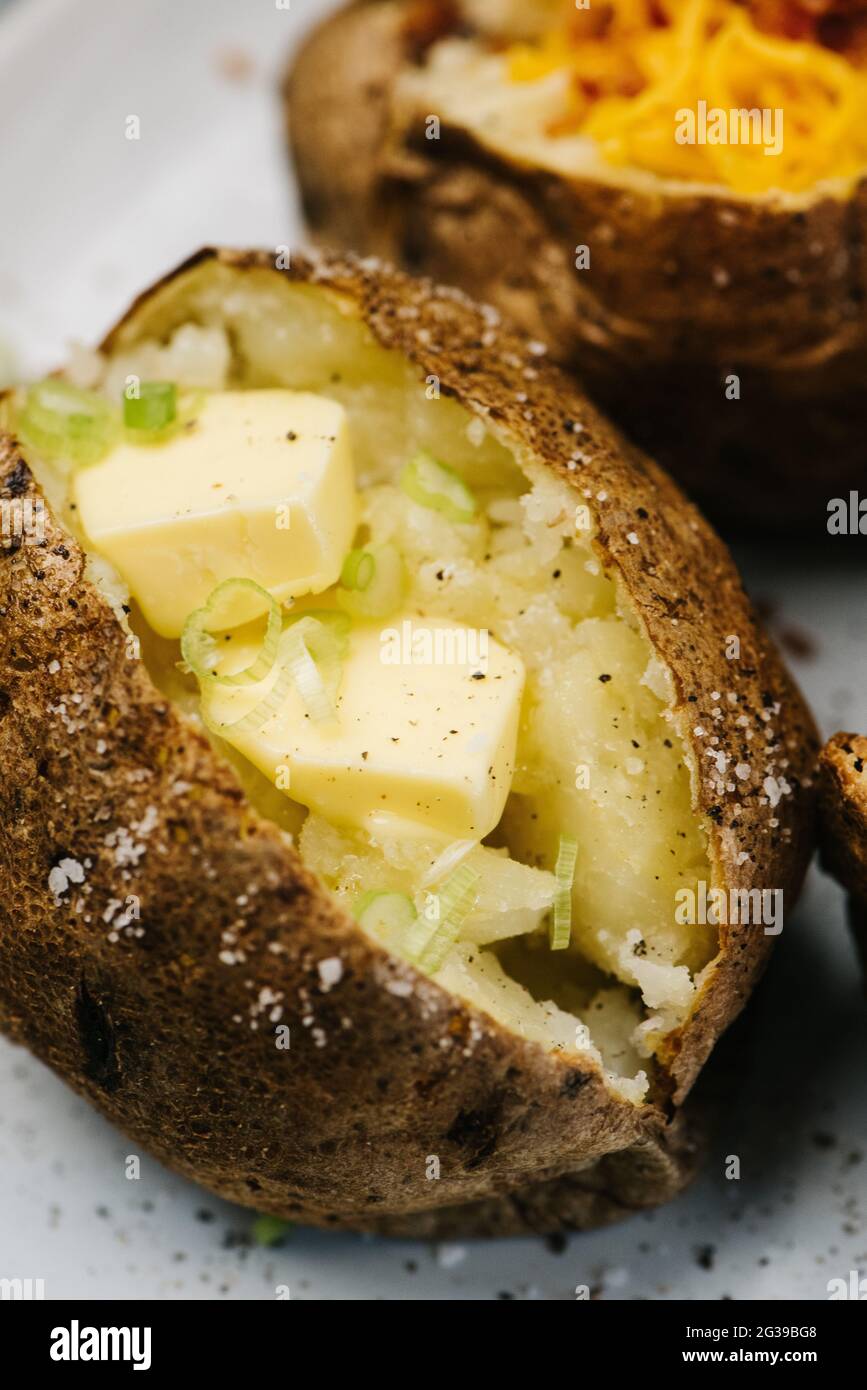 Baked potatoes with butter and green onions Stock Photo Alamy