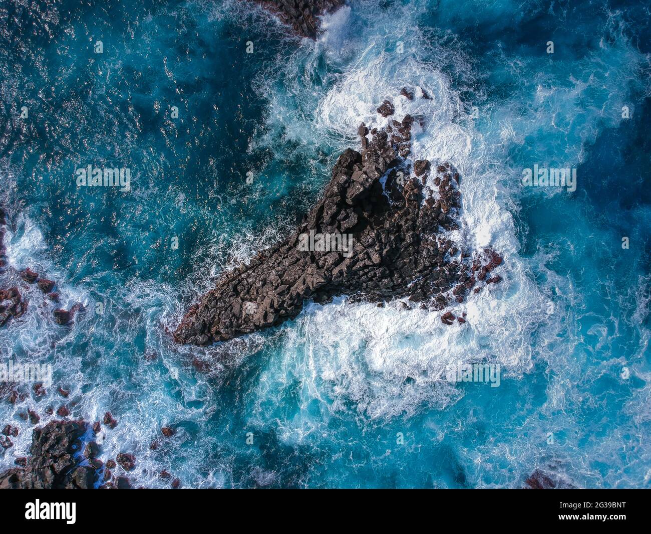 Aerial top view of sea waves hitting black volcanic rocks Stock Photo ...