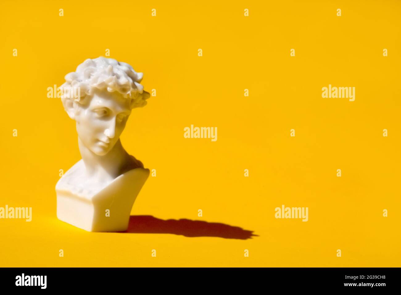 white statue head on yellow background. Ancient greek head sculpture. . High quality photo Stock Photo