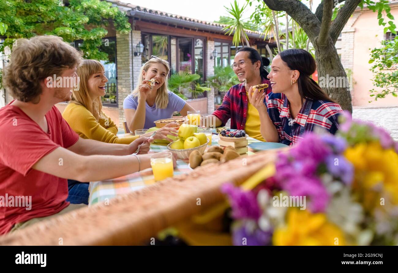 multiethic group of people enjoying sweet breakfast together outdoors ...