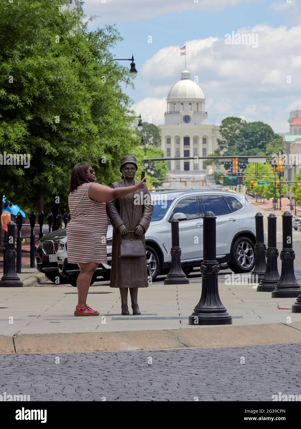 Black African American woman taking a selfie next to the civil rights activist, statue of Rosa Parks in Montgomery Alabama, USA Stock Photo