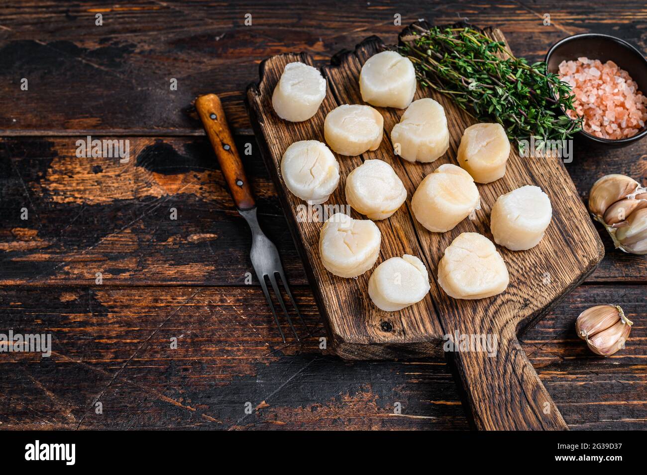 Steamed scallops meat on a wooden board. Dark wooden background. Top ...