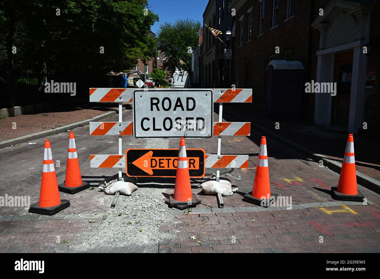 Road Closed and Detour signs with orange traffic cones at a road closure. Stock Photo