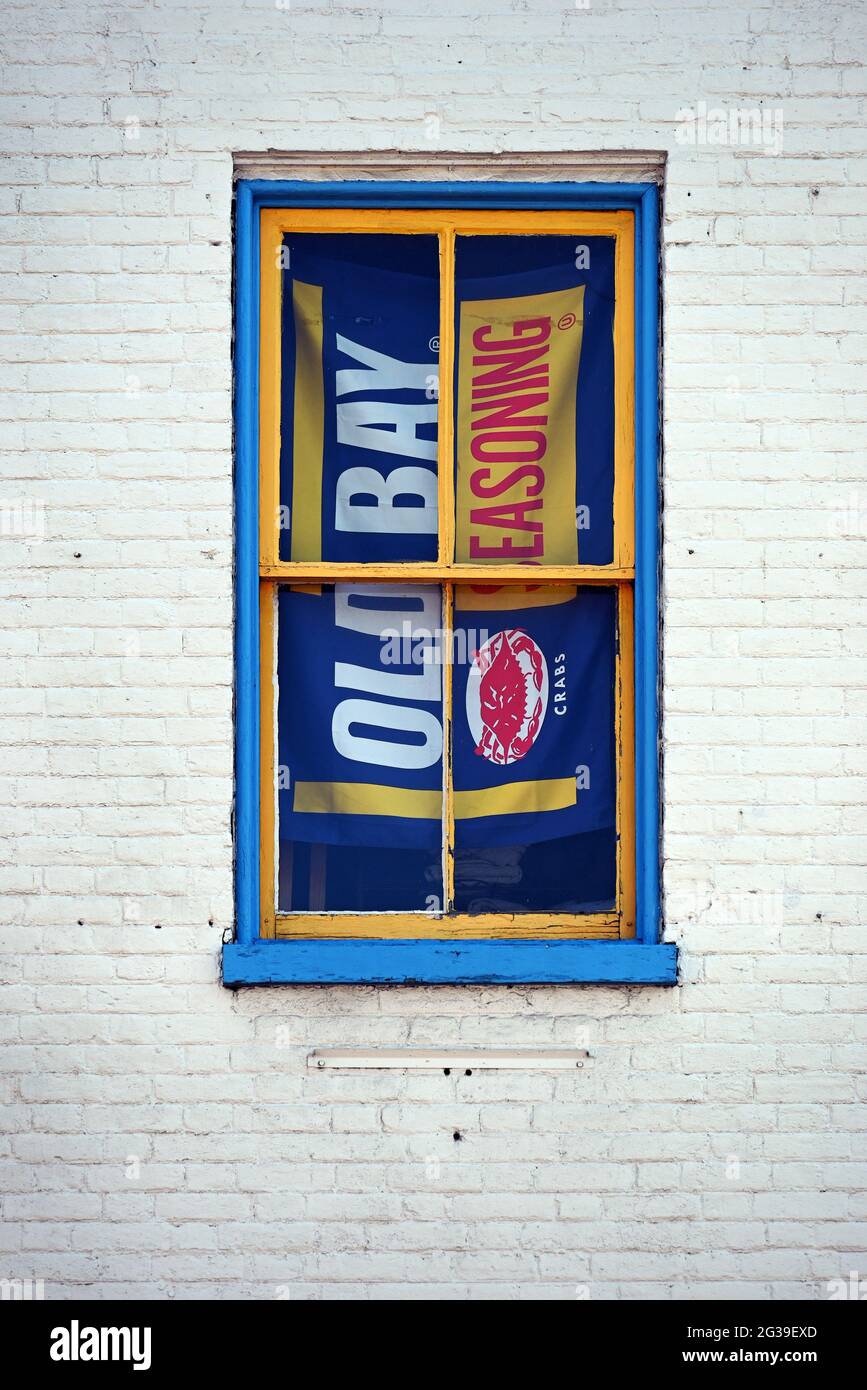A sign in a window advertising Old Bay Seasoning. Stock Photo