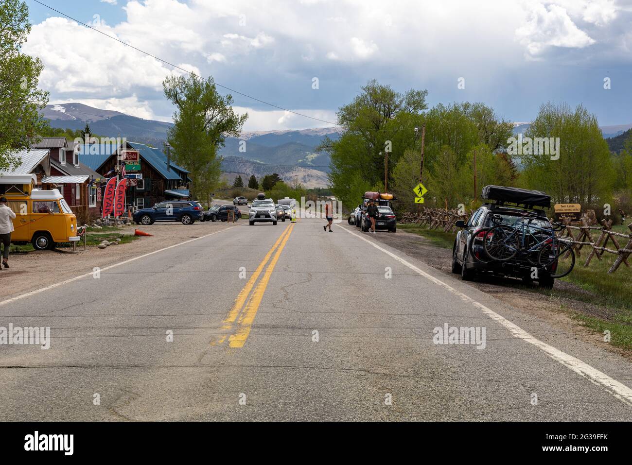 Twin Lakes, Colorado, on Highway 82, tourists crossing the road, cars parked alongside highway. The tourist town is at base of Independence Pass. Stock Photo