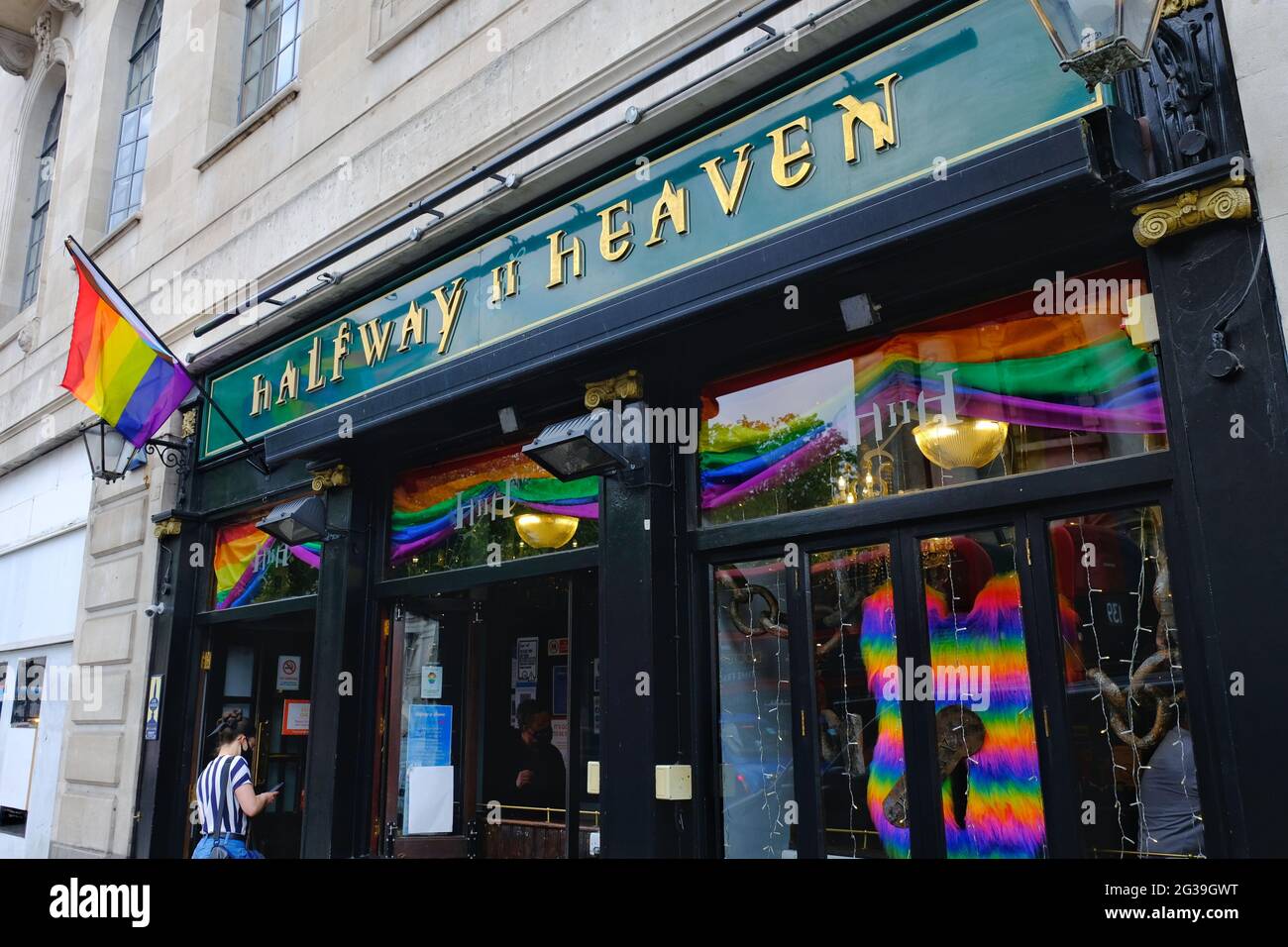 A Progress Pride flag hangs outside a LGBT+ pub. The intersex community and people of colour are acknowledged in the redesign of the Rainbow flag Stock Photo