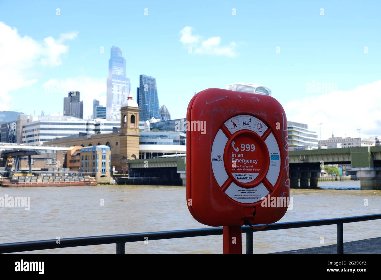 A lifebuoy ring inside box by the Thameside with the City of London buildings in the background. Stock Photo
