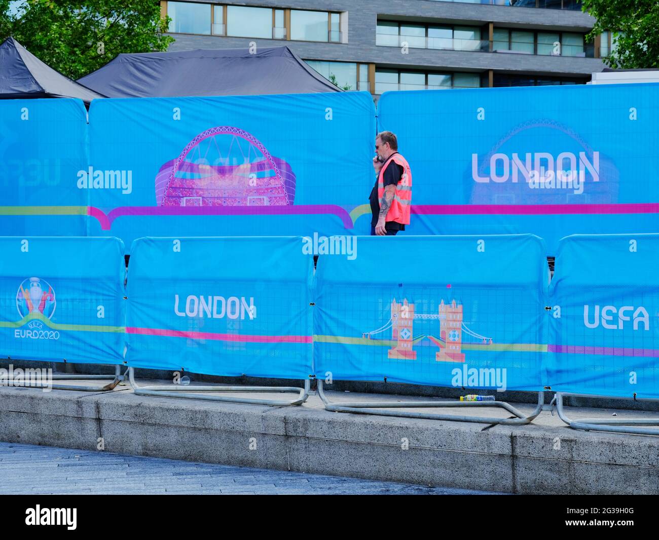 A worker passes across barriers to the Potter's Fields family-friendly Fan Zone run in collaboration with UEFA and the Mayor of London. Stock Photo