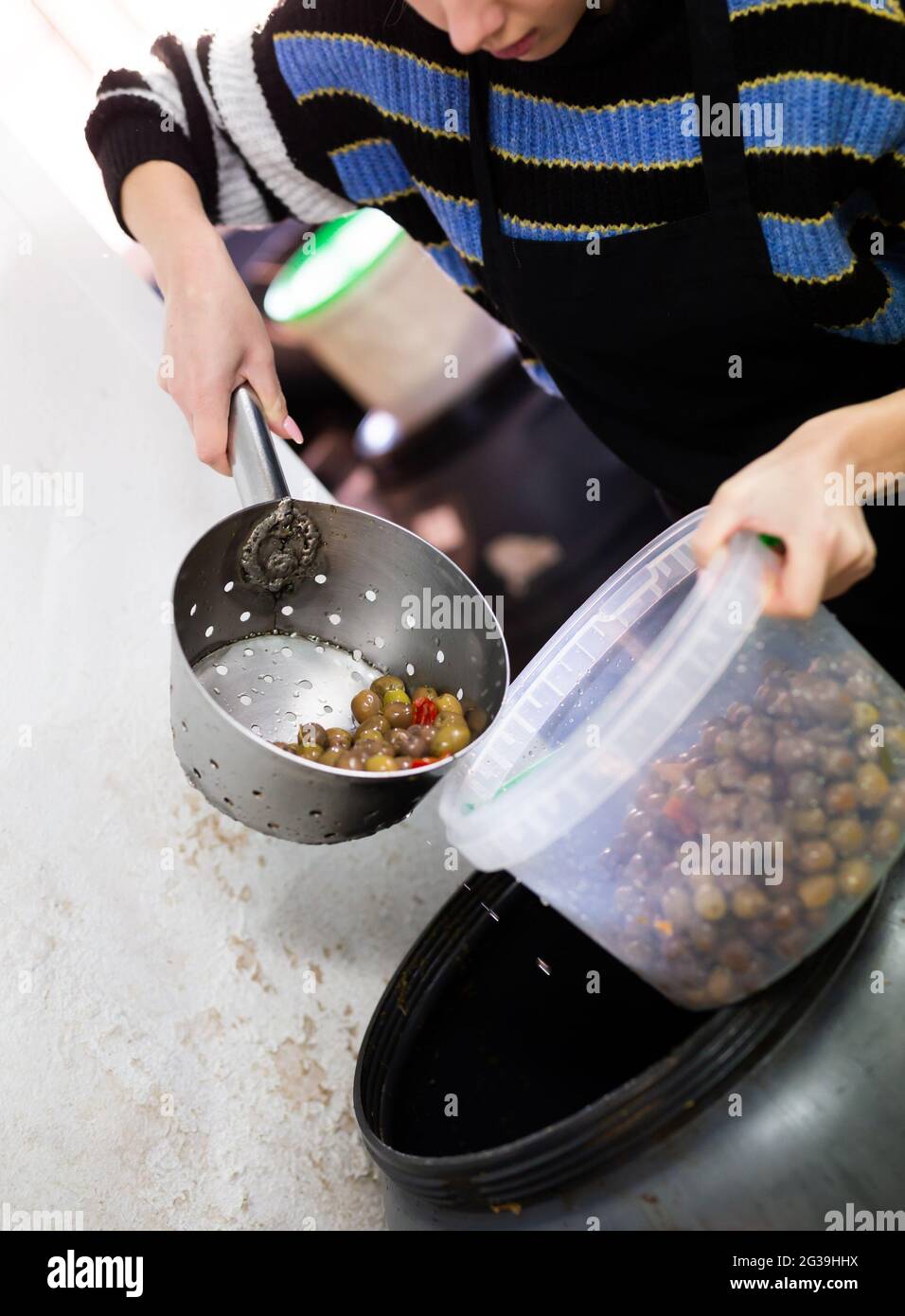 Female taking pickled olives from brine Stock Photo Alamy