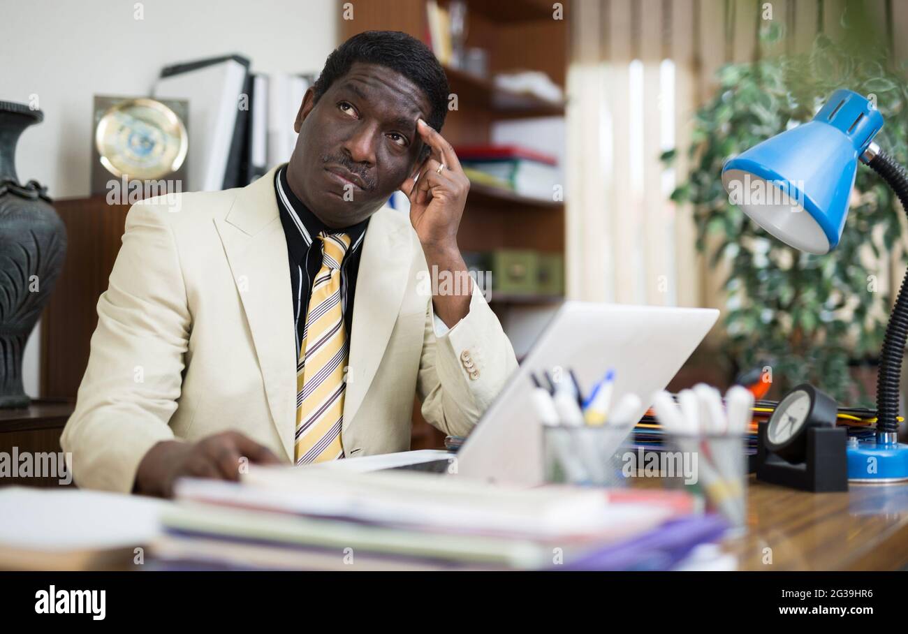 Pensive african american man working in modern office Stock Photo