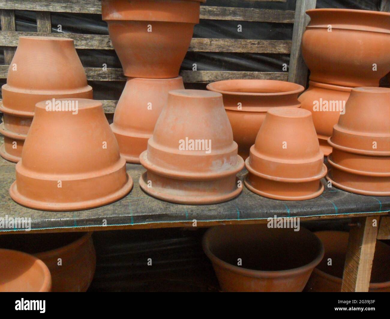 clay pots for plants in different shapes and sizes for sale on a shelf