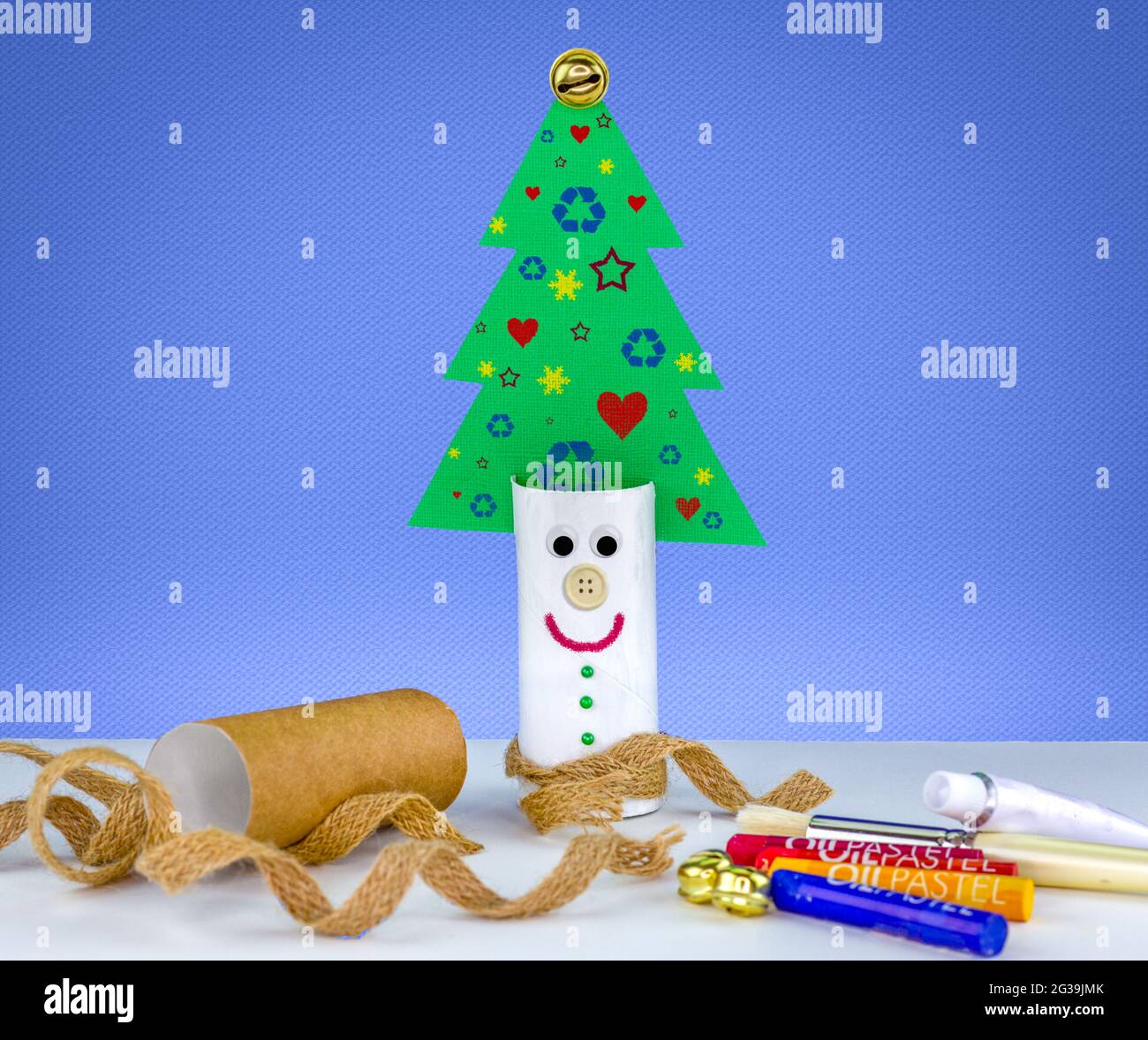 Recycle toilet roll tube, decorated and reused to make fun Christmas tree decoration with smiling face, homemade quirky craft fun. Stock Photo