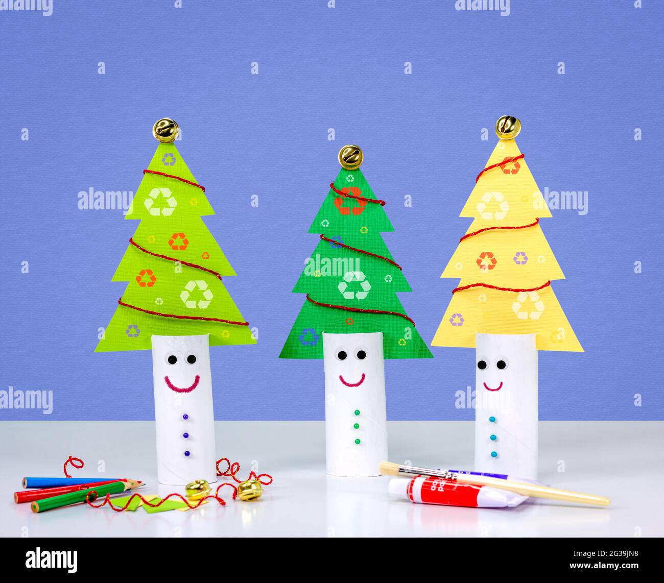 Recycle toilet roll tubes, decorated and reused to make fun Christmas tree decoration with smiling face, homemade quirky craft fun. Stock Photo