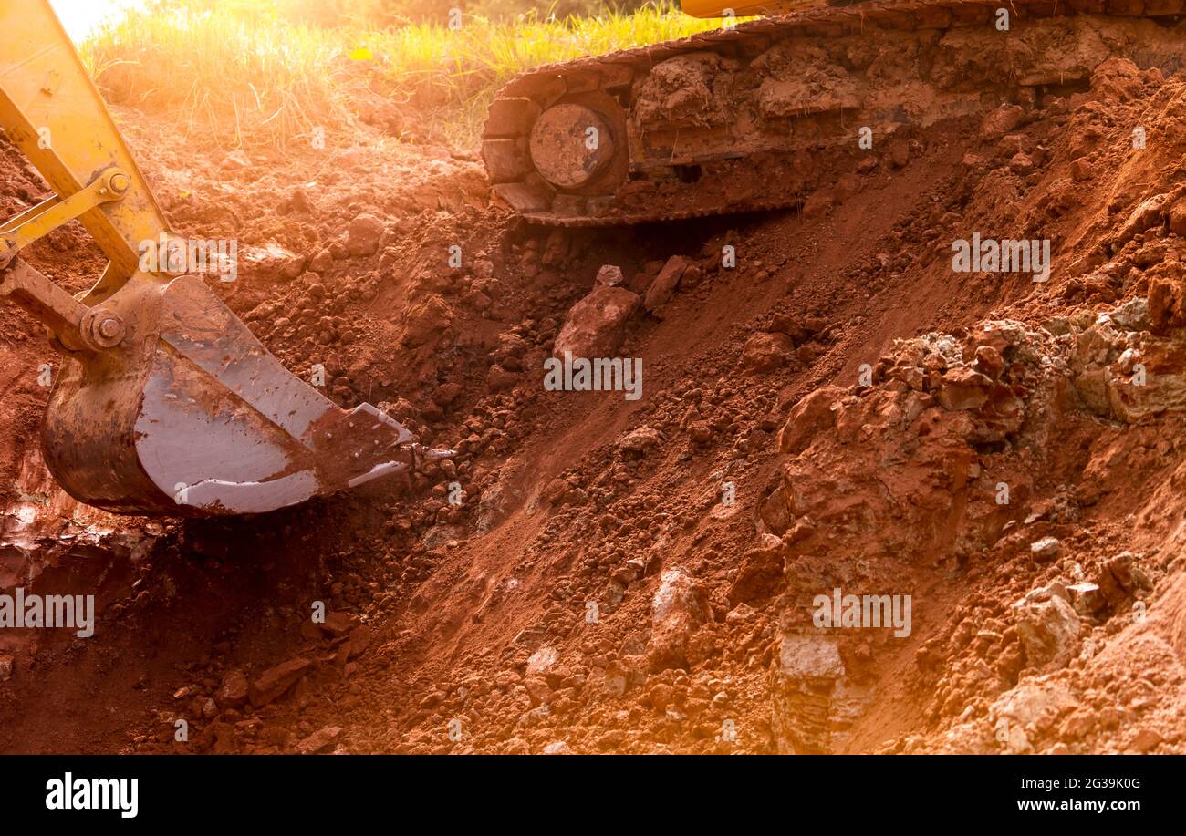 Backhoe working by digging soil at construction site. Bucket of backhoe