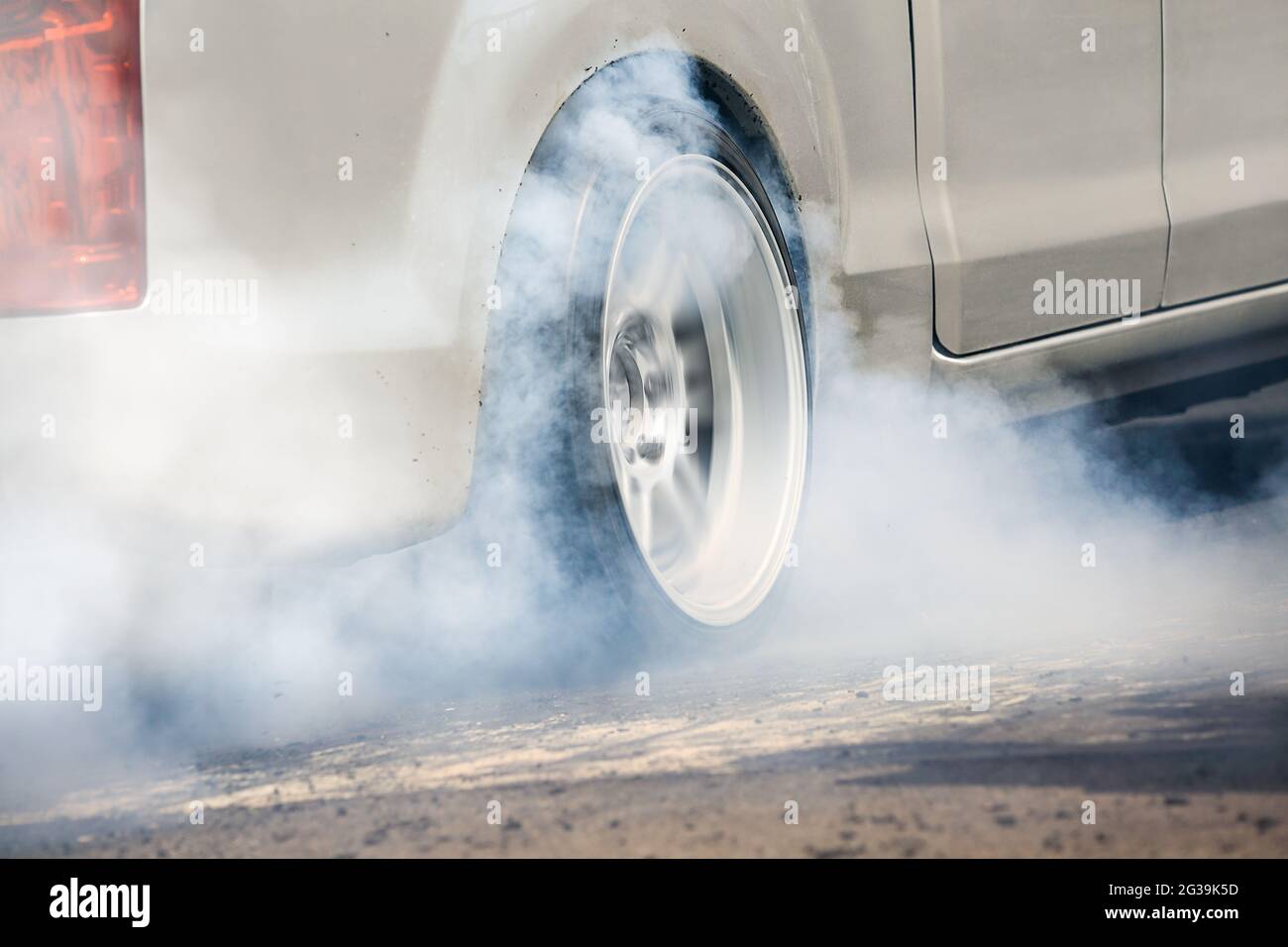 Drag racing car burns rubber off its tires in preparation for the race ...