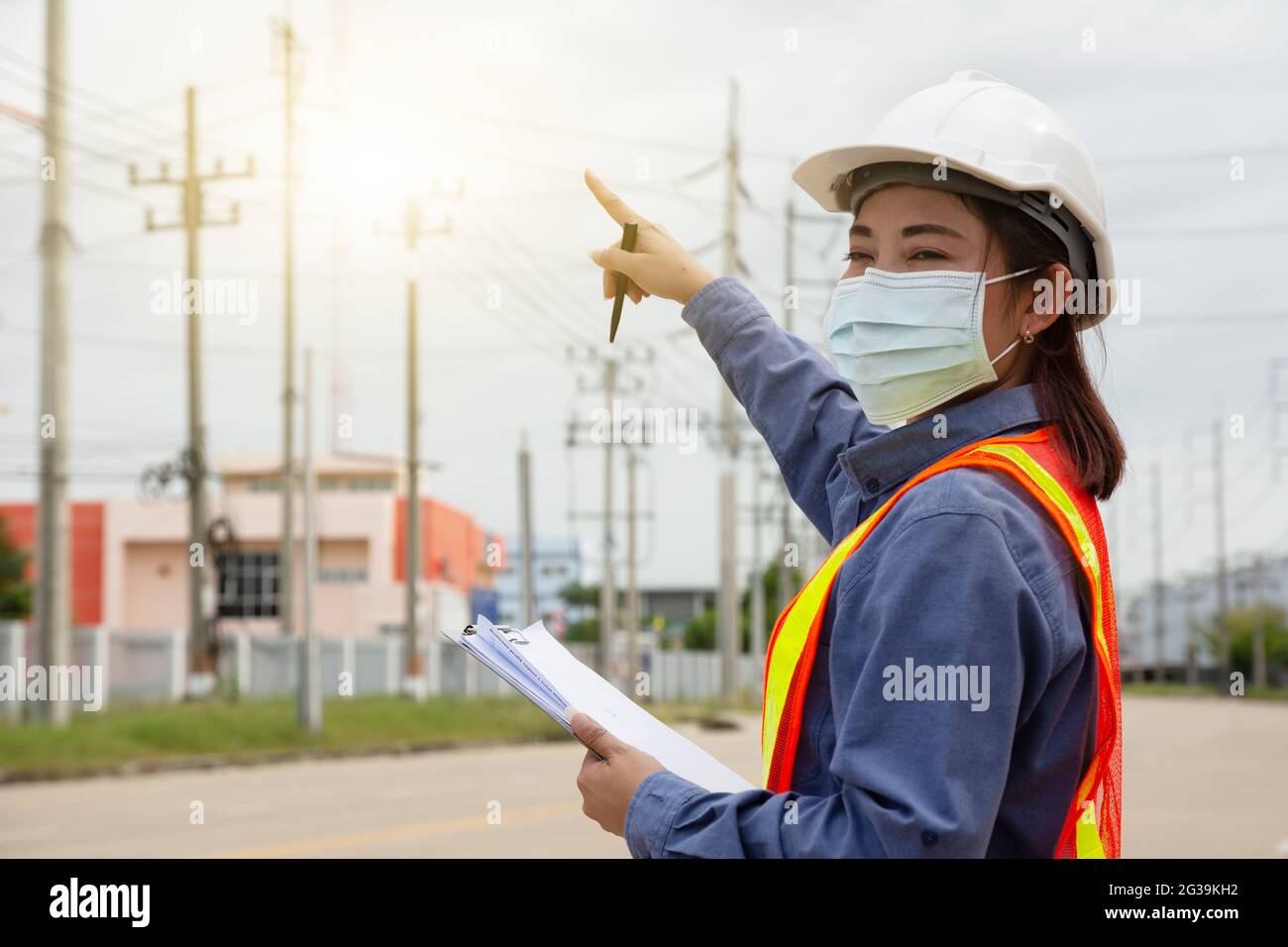Hand holding clipboard and write on document checklist high voltage system, Working woman Stock Photo