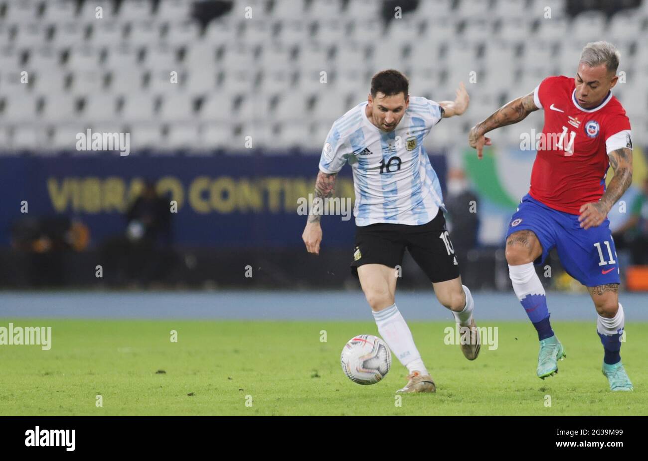 Rio De Janeiro, Brazil. 14th June, 2021. Lionel Messi (L) of Argentina vies with Eduardo Vargas of Chile during the Group A match between Argentina and Chile at the 2021 Copa America in Brasilia, Brazil, June 14, 2021. Credit: Rahel Patrasso/Xinhua/Alamy Live News Stock Photo