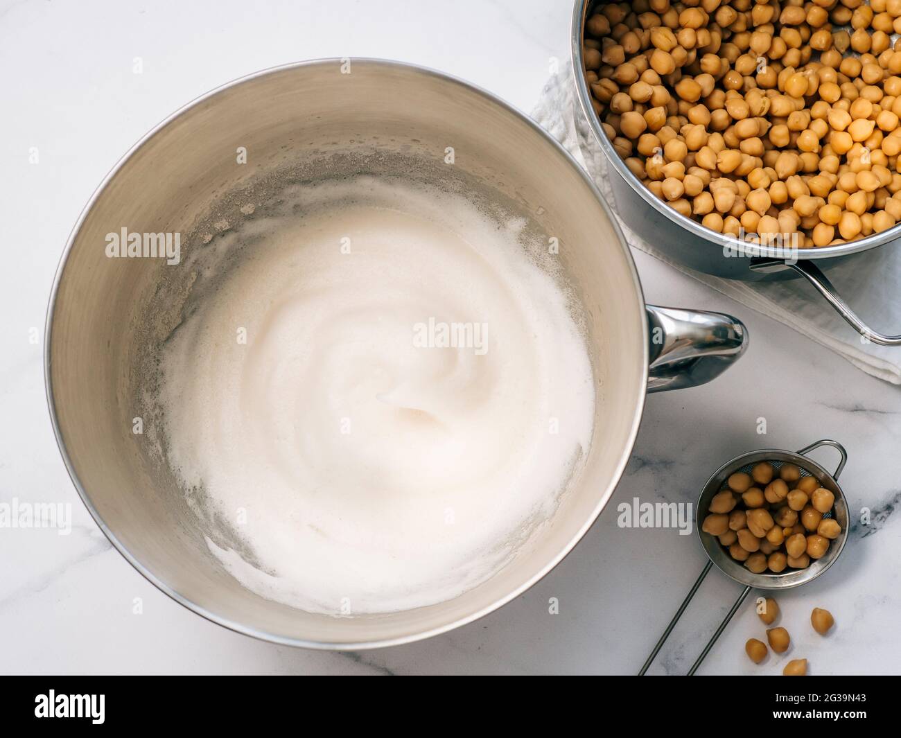 Whipped aquafaba in mixer bowl, vertical. Chickpea water