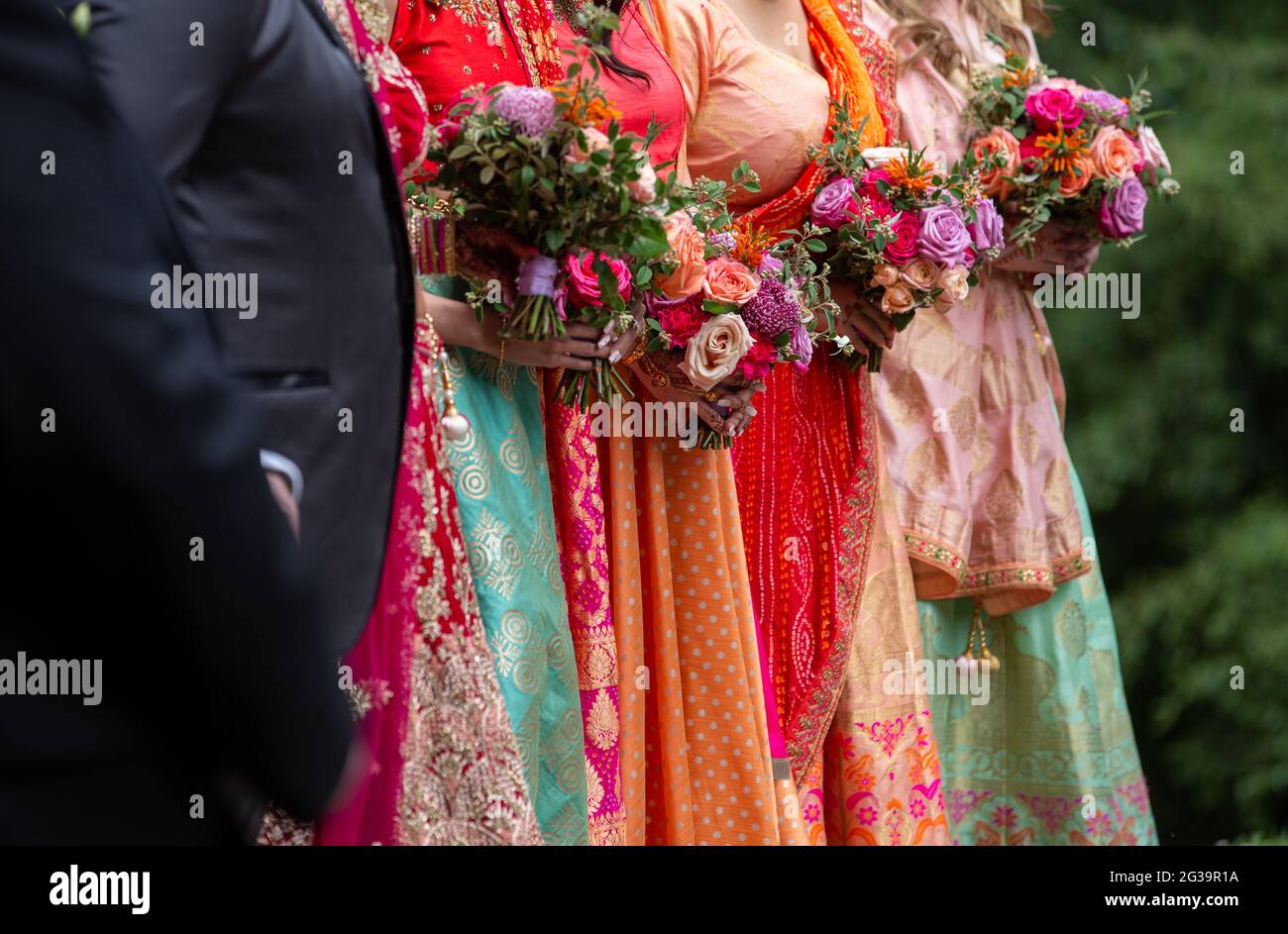 Bride and bridesmaids wearing saris and holding flowers at a wedding in Australia Stock Photo
