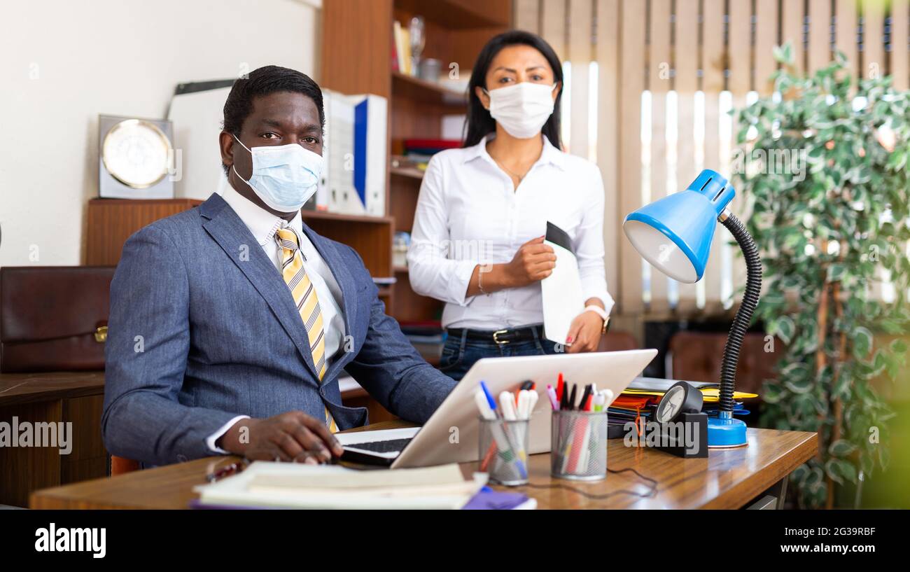 Businessman and businesswoman in protective mask working together Stock ...