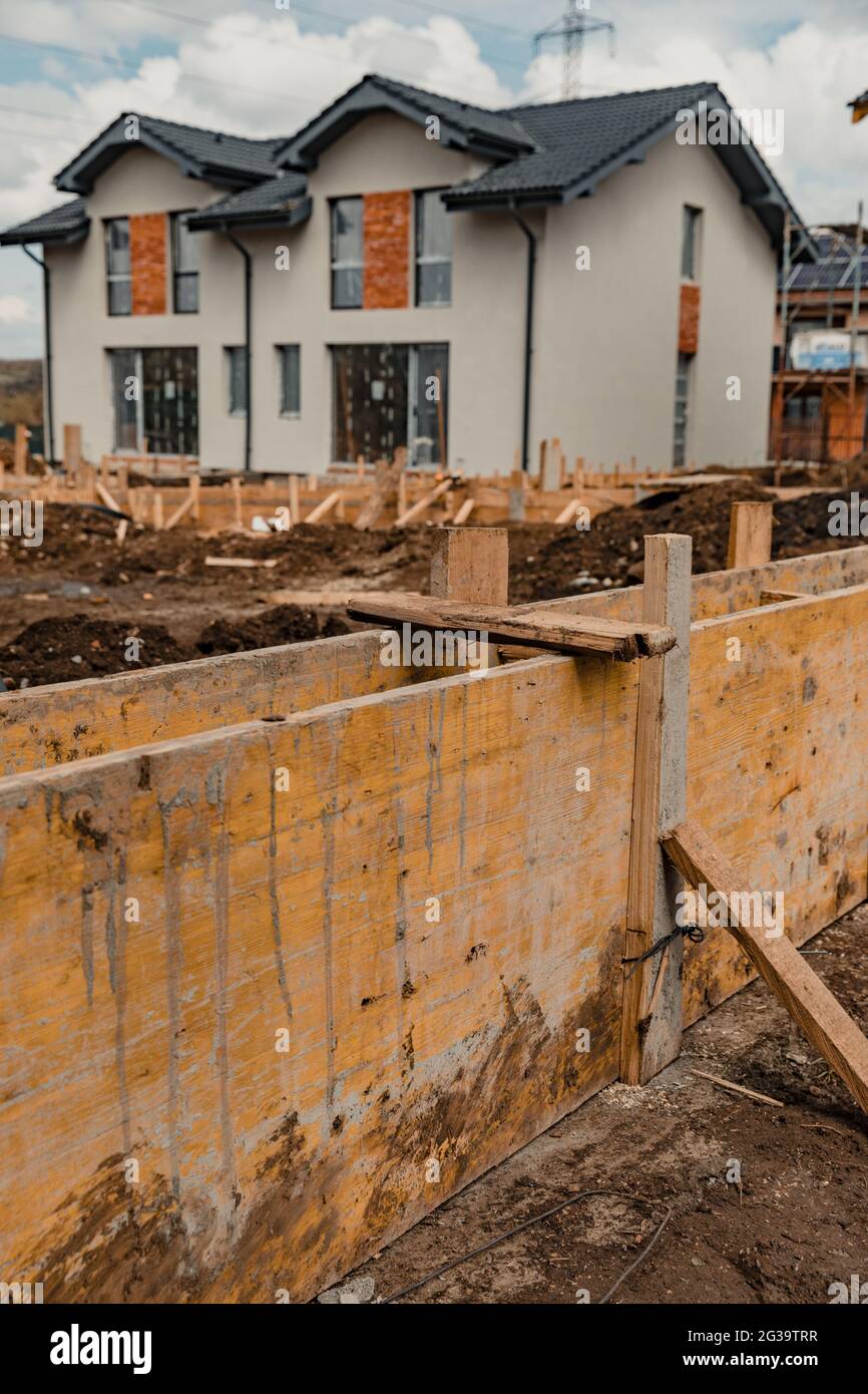 Vertical shot of the newly built houses under a cloudy sky - foundation ...