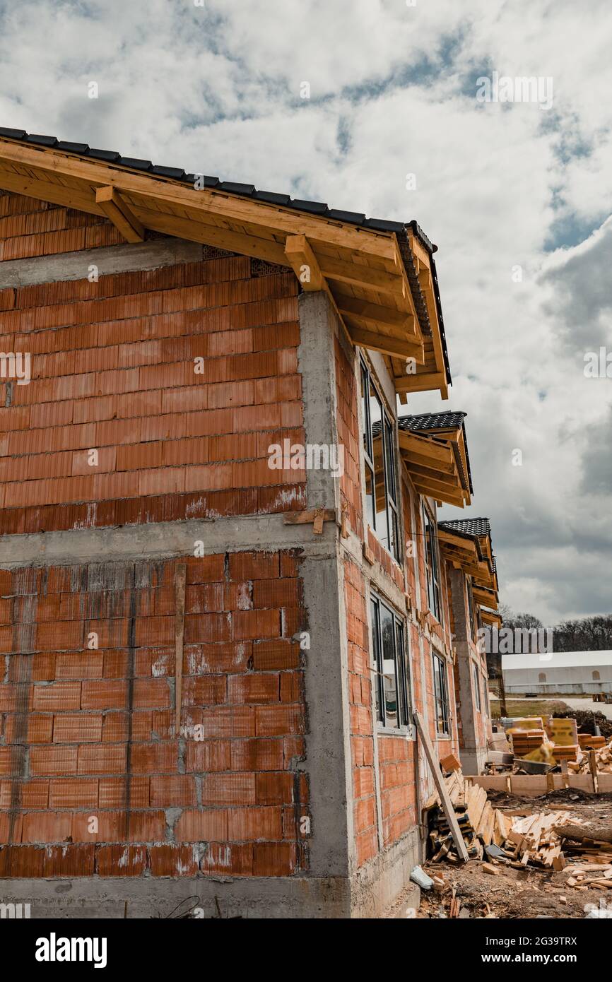 Vertical shot of the newly built orange houses under a cloudy sky ...